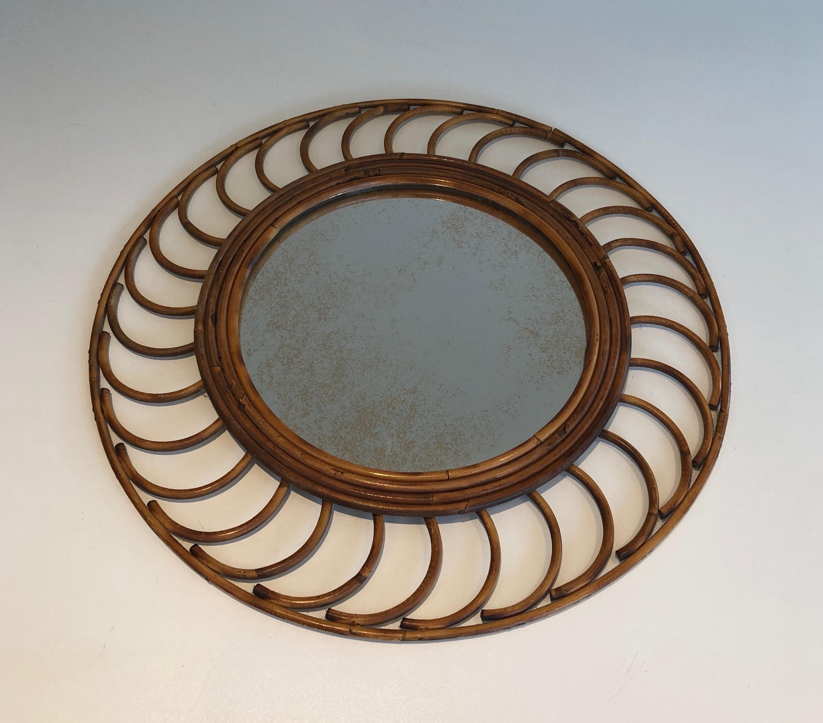 Ce joli miroir rond est fabriqué en rotin. Il s'agit d'une œuvre française. circa 1970.