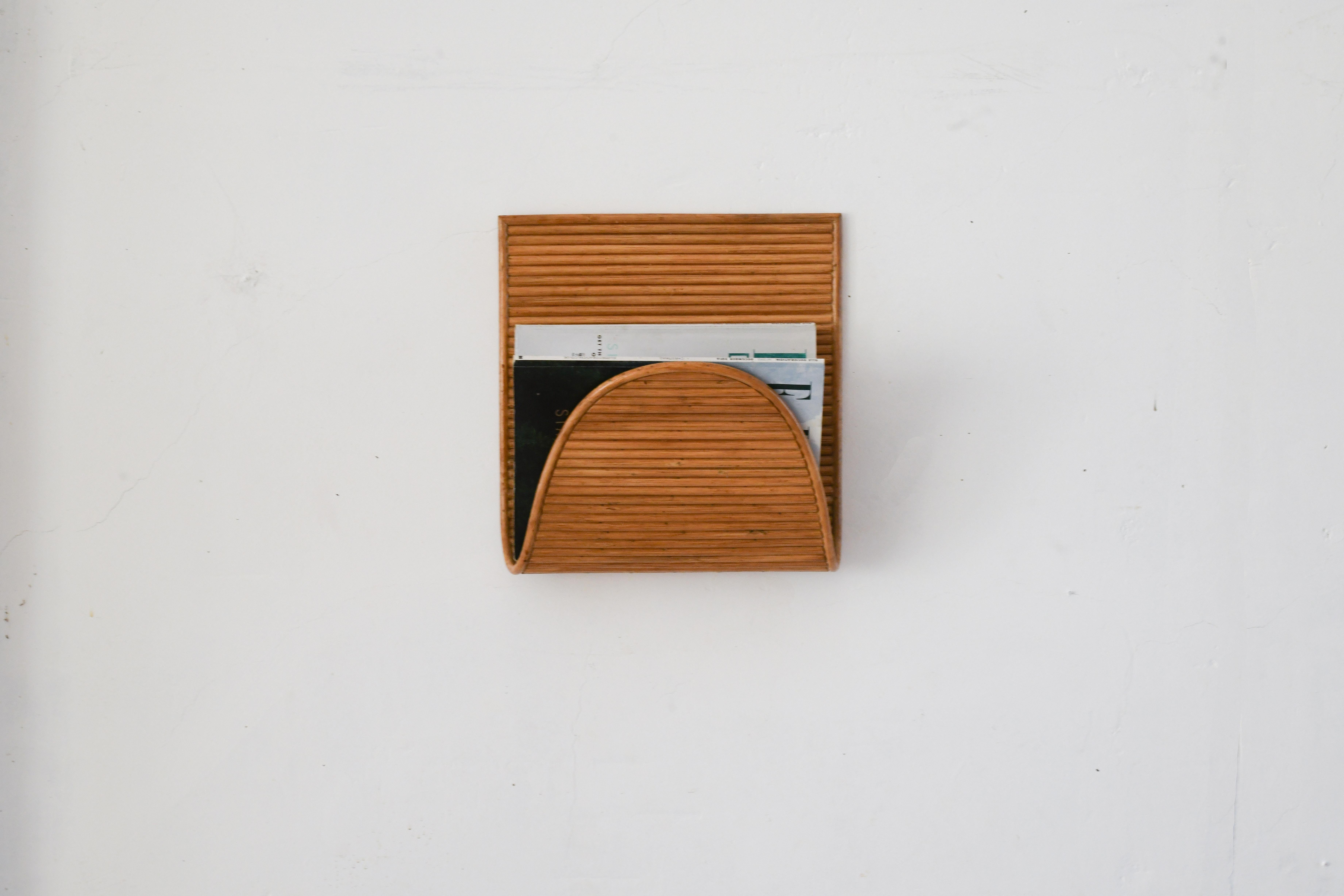 Rattan Modern Wall 
Mounted Magazine Rack Aldo, 
This stylish and functional wall-mounted rattan magazine rack embodies the clean lines and natural materials characteristic of danish mid-century design.
Its of rattan cane construction that adds a