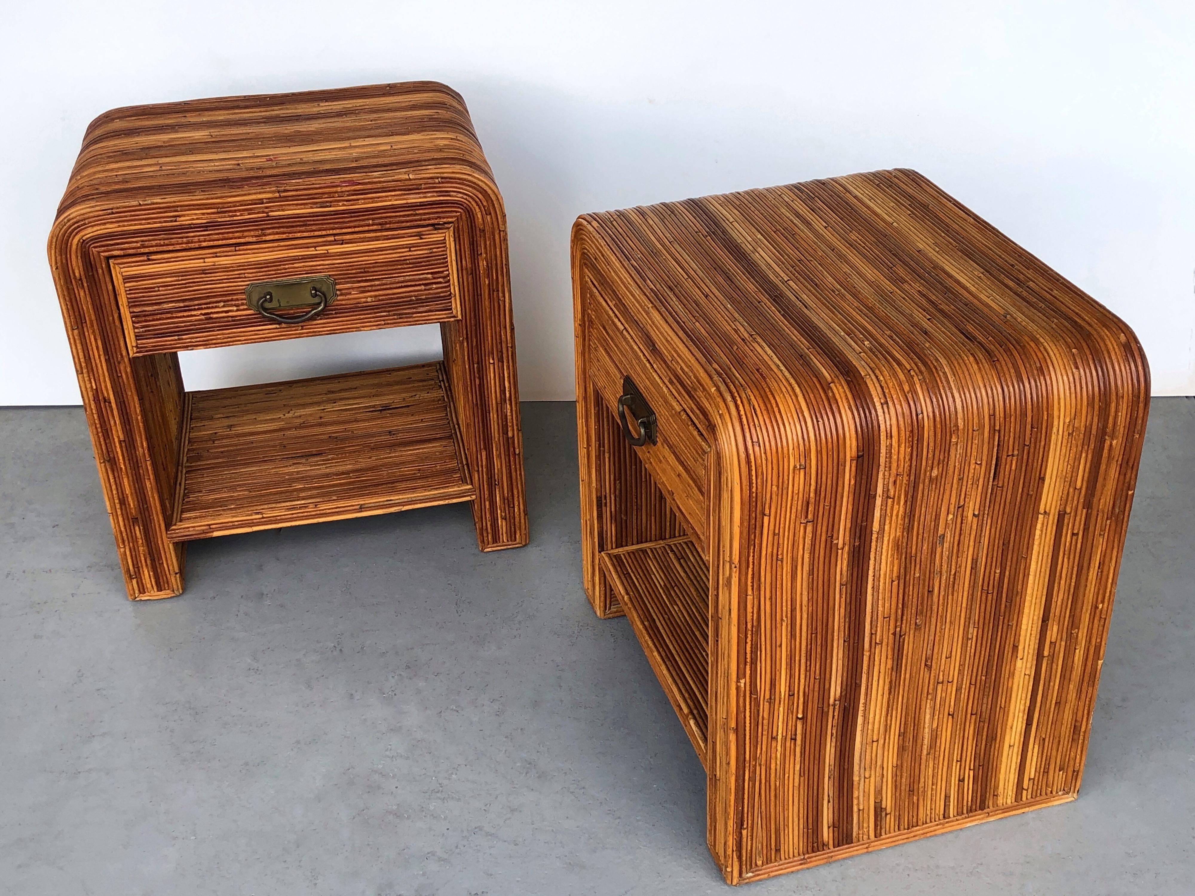 A pair of side tables in pencil rattan. Waterfall design with brass pulls. Finished in all sides.
