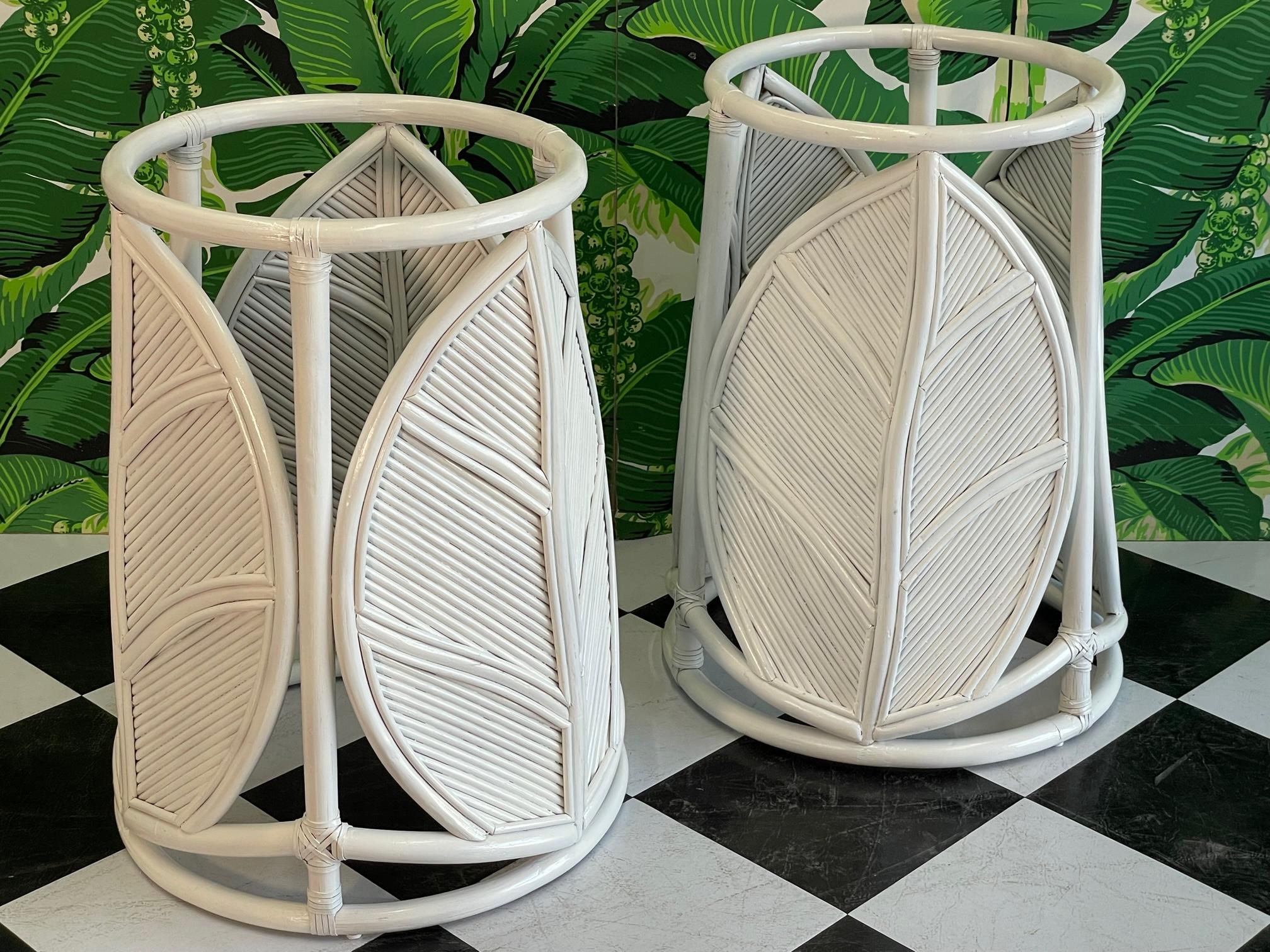Pair of rattan dining table pedestals feature a large leaf motif with pencil reed detailing. Can support large glass tops or can be used as individual tables with your glass tops. Good condition with minor imperfections to the newly lacquered gloss