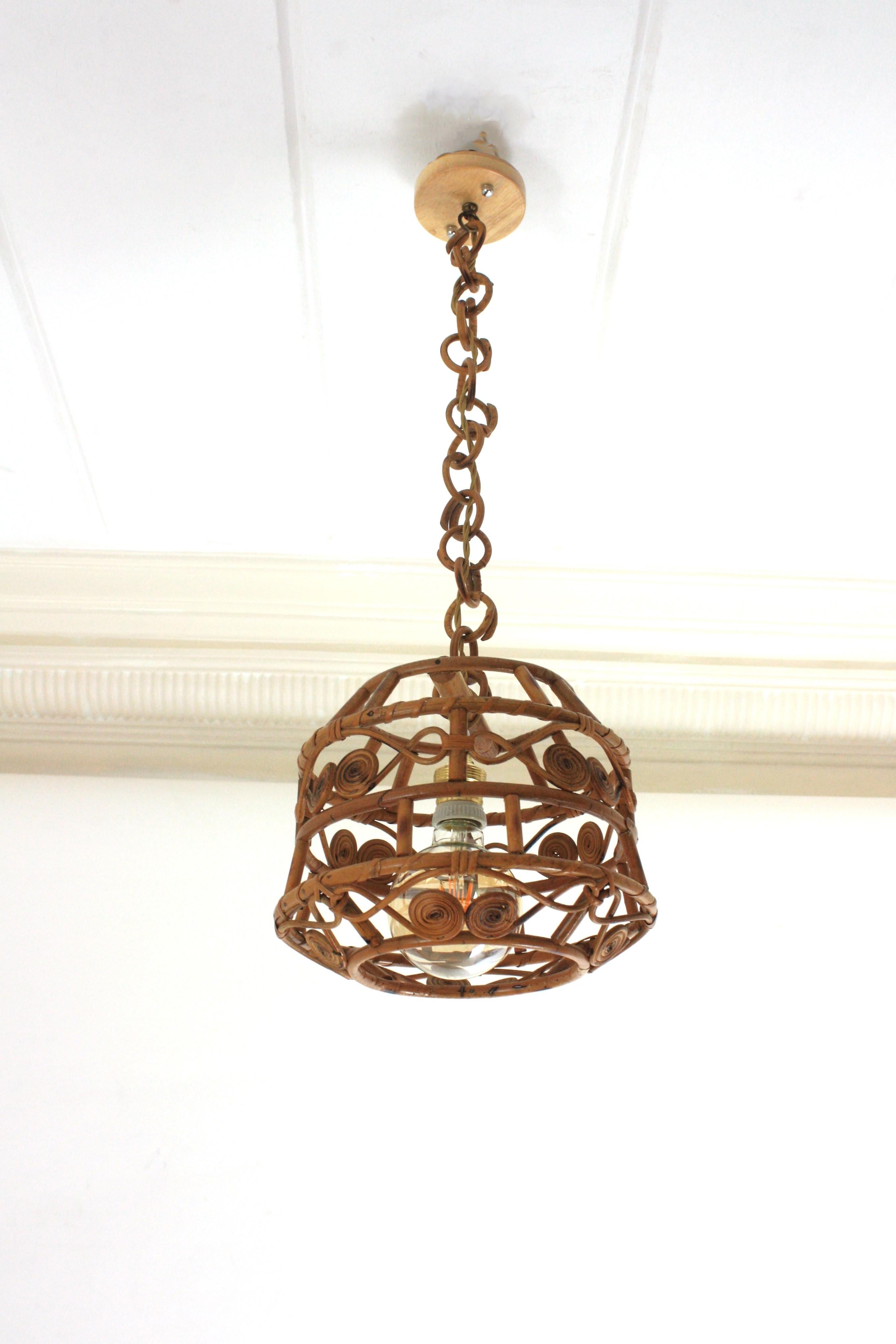 Accattivante lampada a sospensione o lanterna in vimini/rattan realizzata a mano con lavorazioni artistiche in filigrana. Spagna, anni '60
Questo ciondolo in rattan presenta una struttura del paralume tutta in canna con bellissimi motivi a volute e