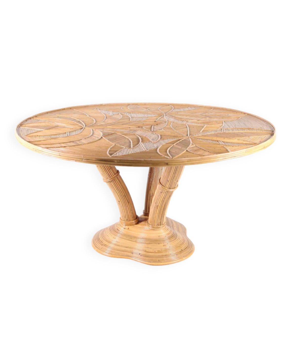 Excepcional mesa de comedor redonda de ratán. Patas de trípode figurando un árbol, parte superior con motivos de follaje cubierta por una gruesa tapa de cristal pulido.
Obra Hand Made de alta calidad en excelente estado.
