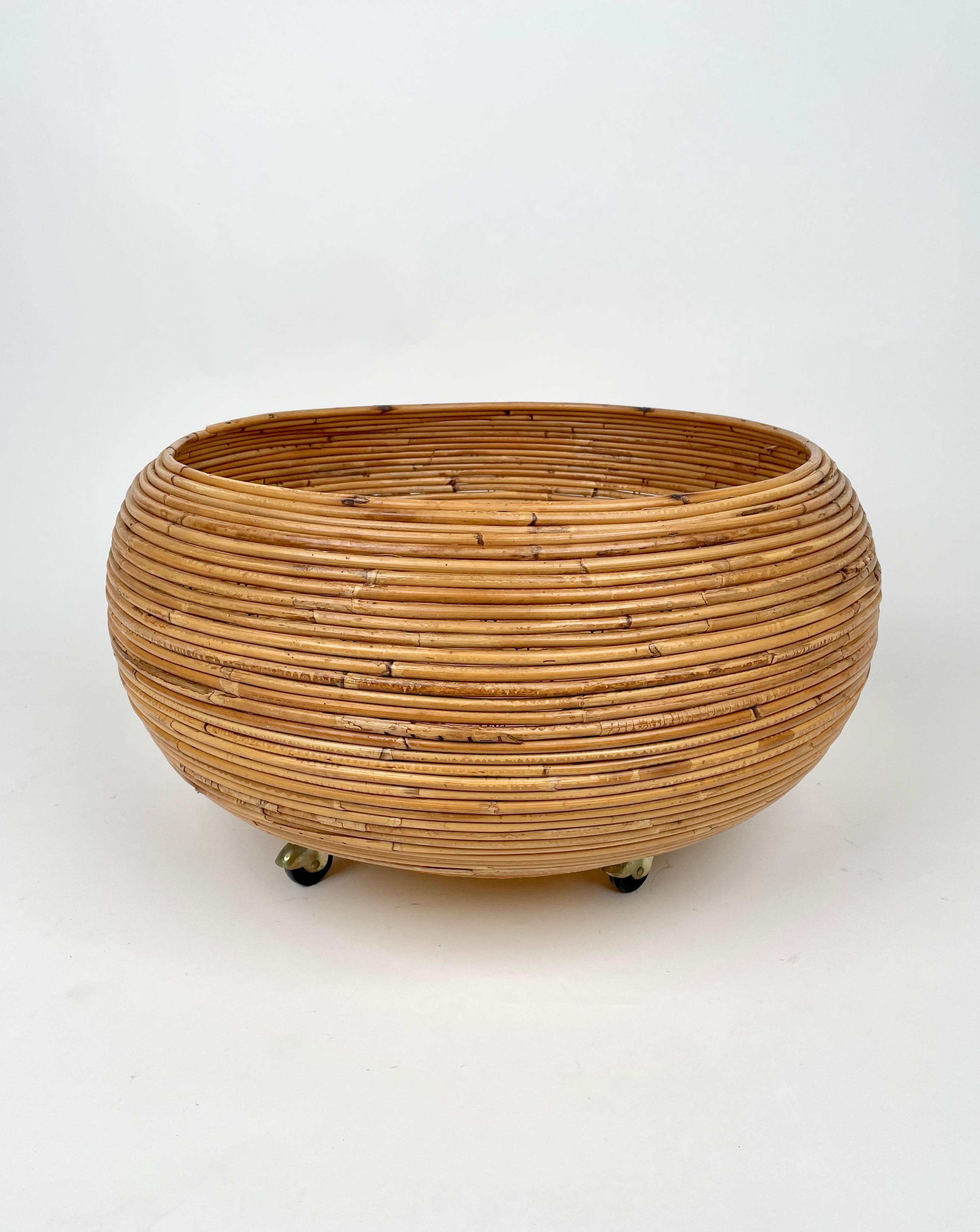 Round flower stand plant holder in rattan with wheels. Made in Italy in the 1960s.