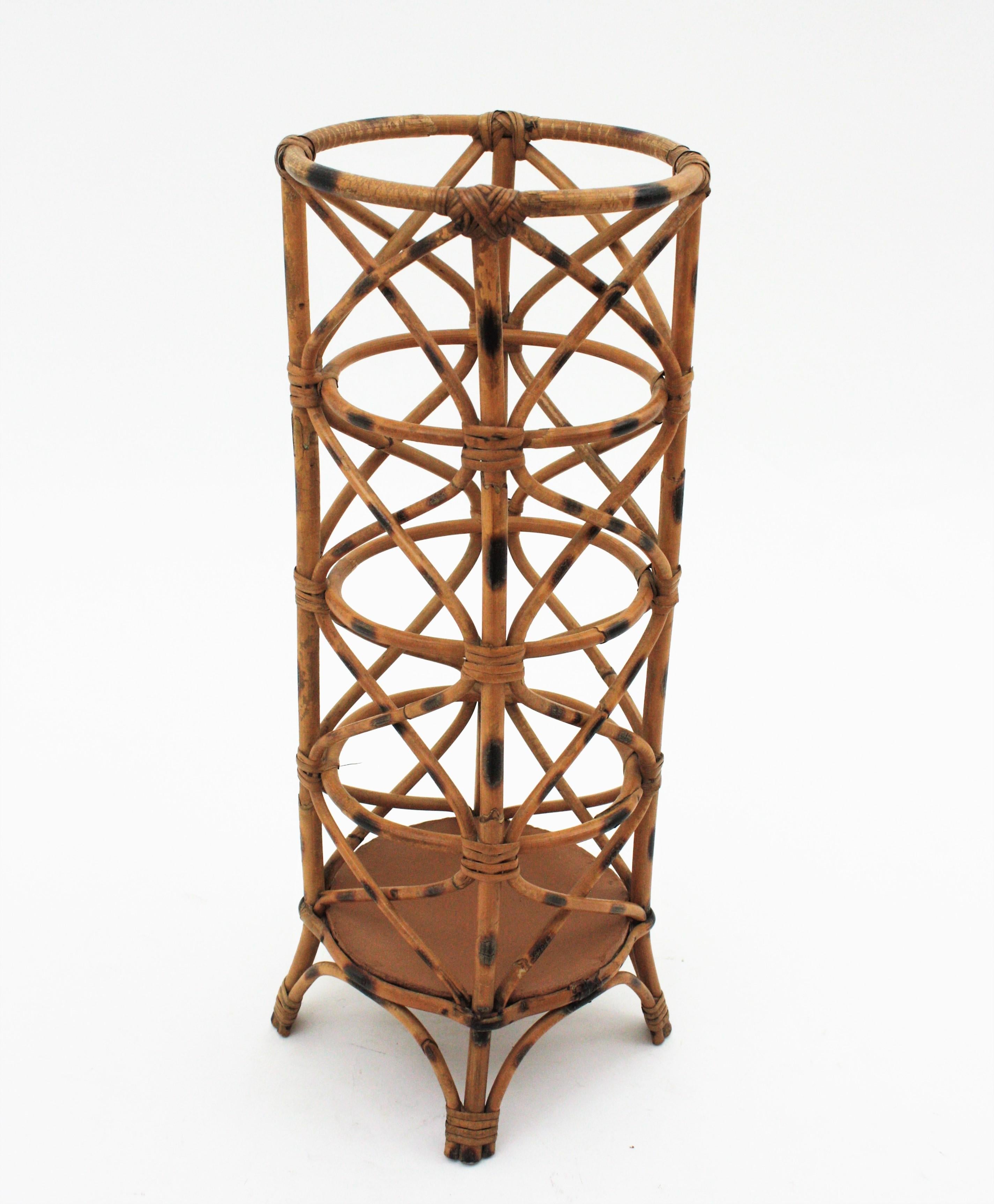 Beautiful Mid-Century Modern decorative bamboo rattan umbrella holder or tall planter. Handcrafted in Italy, 1970s.
This umbrella stand features an eye-catching construction made of rattan with pyrograohy accents.
It is in good vintage condition.