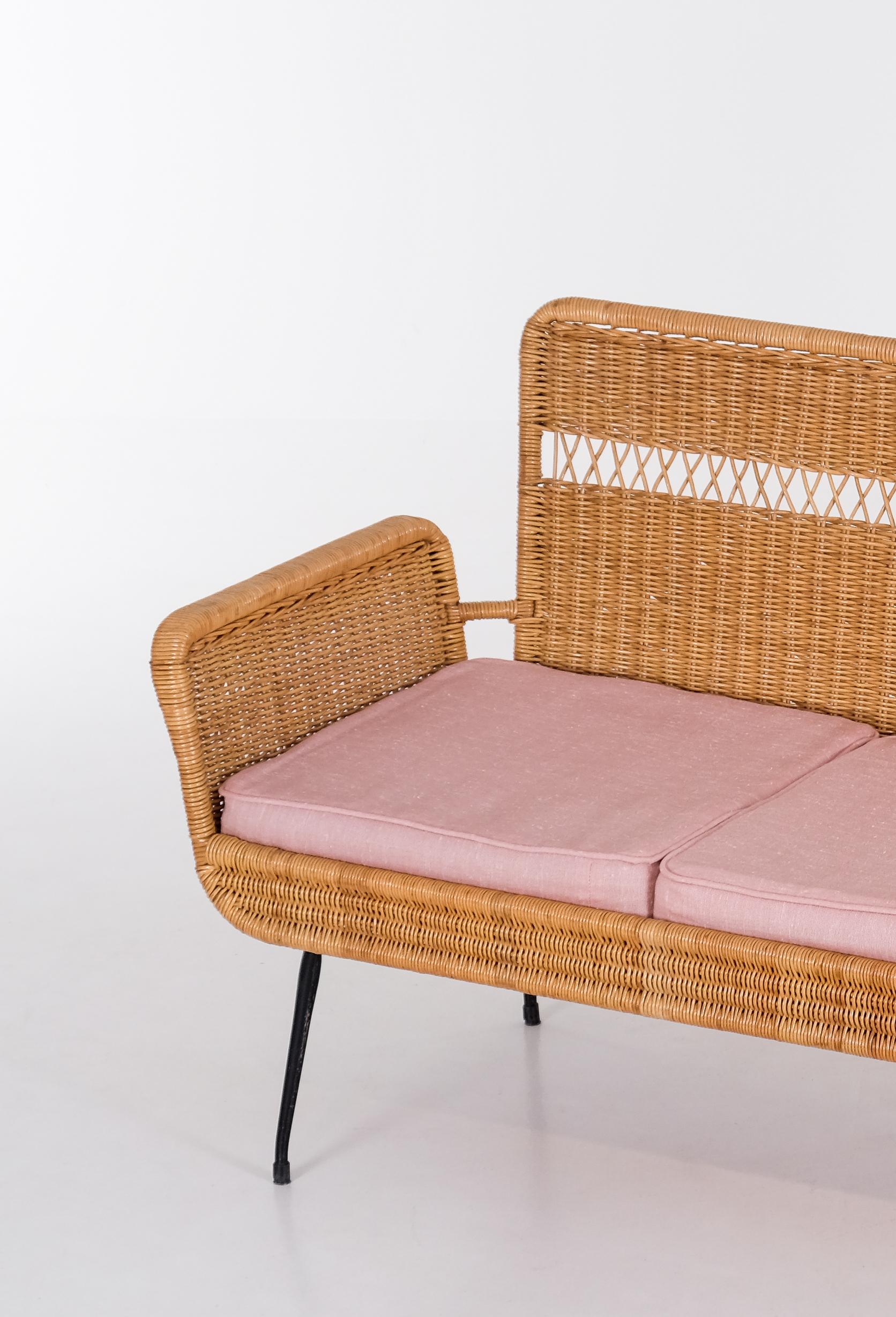 Sofá de ratán con patas de acero lacado en negro. Producido en Brasil, década de 1960.
Muy buen estado con pequeños signos de uso. 
Nota: mesa y sillas a juego también disponibles. 