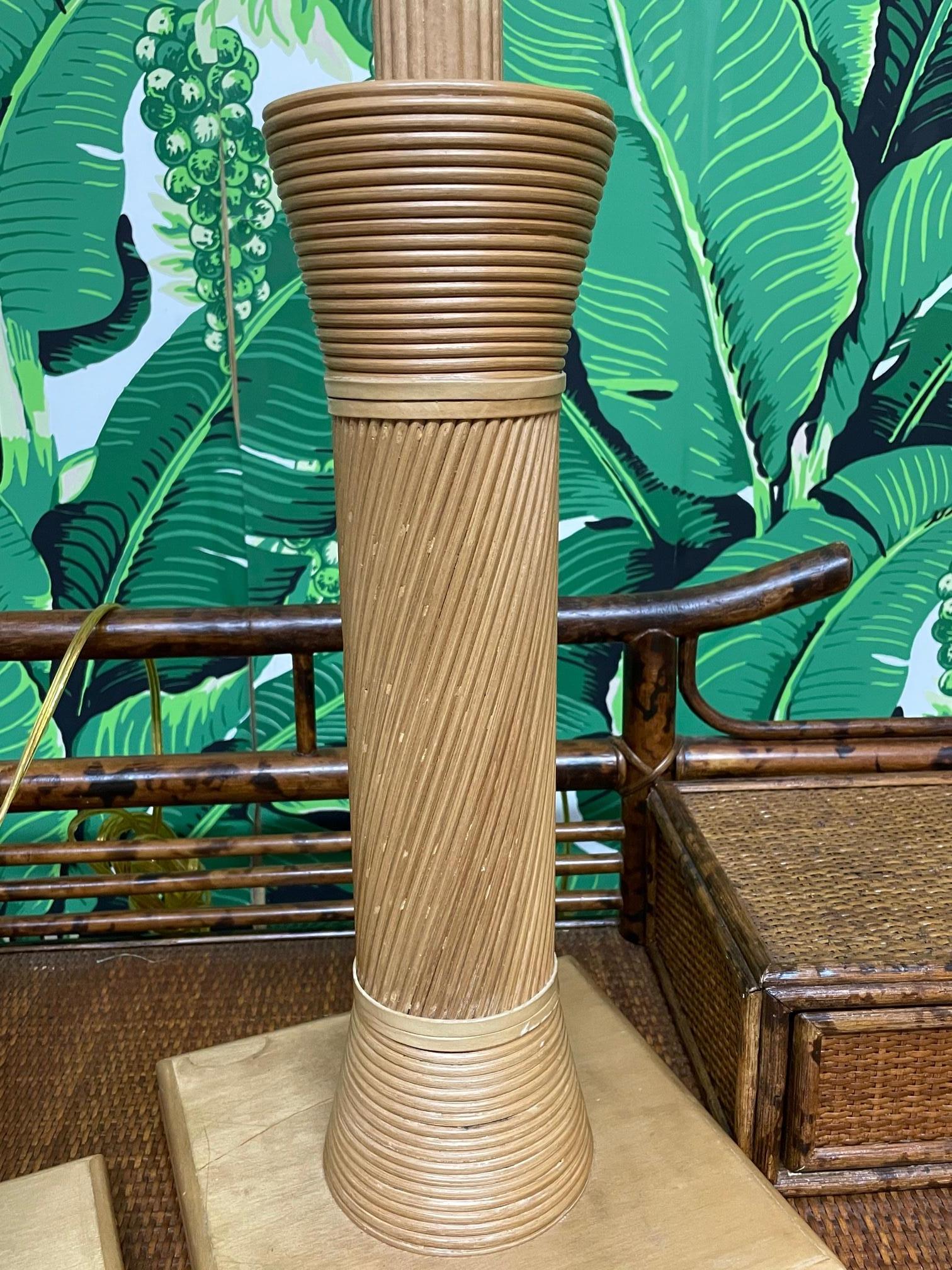 Pair of midcentury table lamps veneered in pencil reed rattan. In the style of  Betty Cobonpue. Very good condition with only very minor imperfections consistent with age.