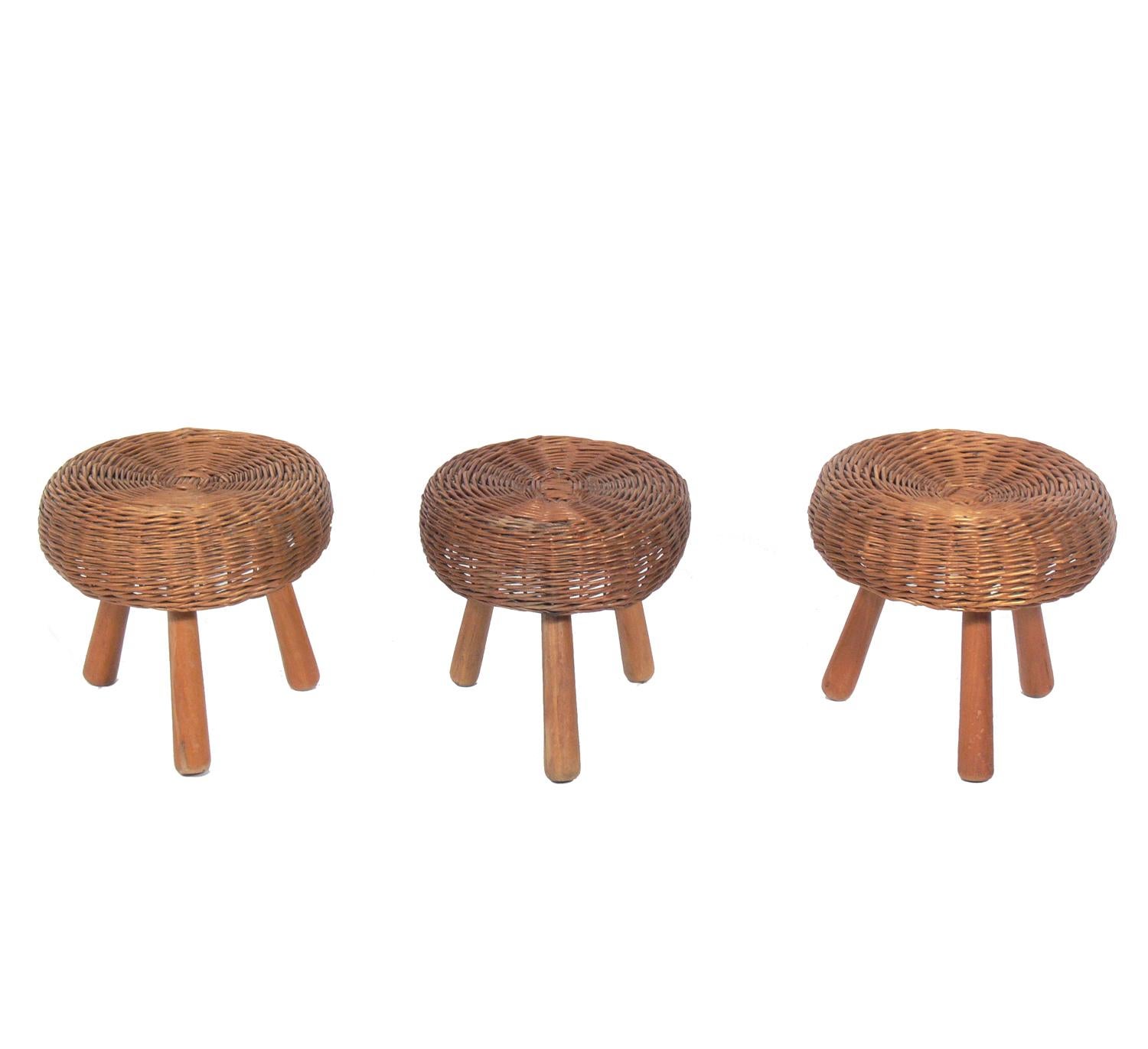 Set of three rattan stools in the manner of Charlotte Perriand, probably French, circa 1950s. They retain their warm original patina.
