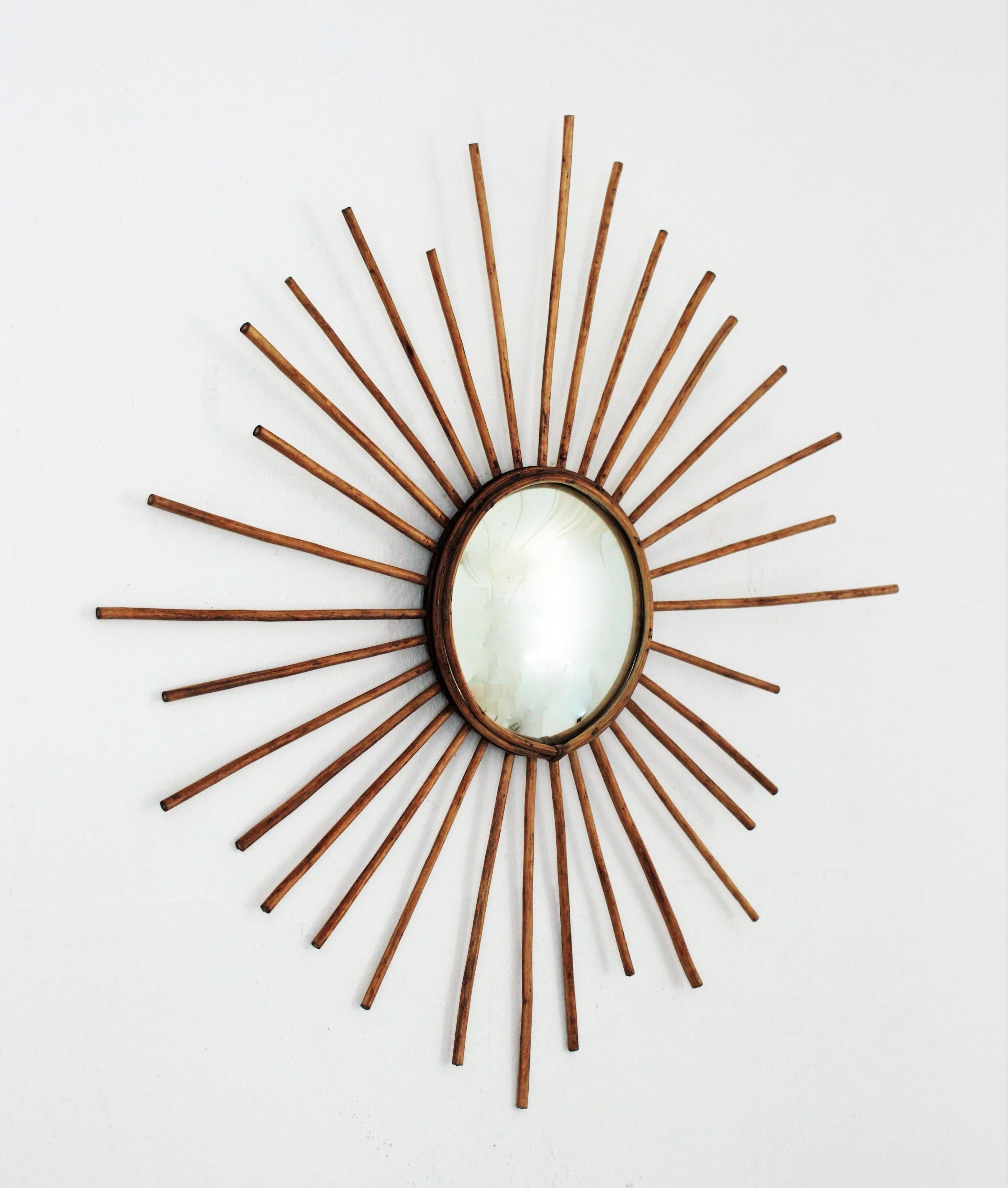 A beautiful rattan starburst sunburst mirror with convex glass, France, 1960s.
This handcrafted mirror has all the taste of the Mediterranean French Riviera. It will be a nice addition placed alone or as a part of a large rattan mirrors wall