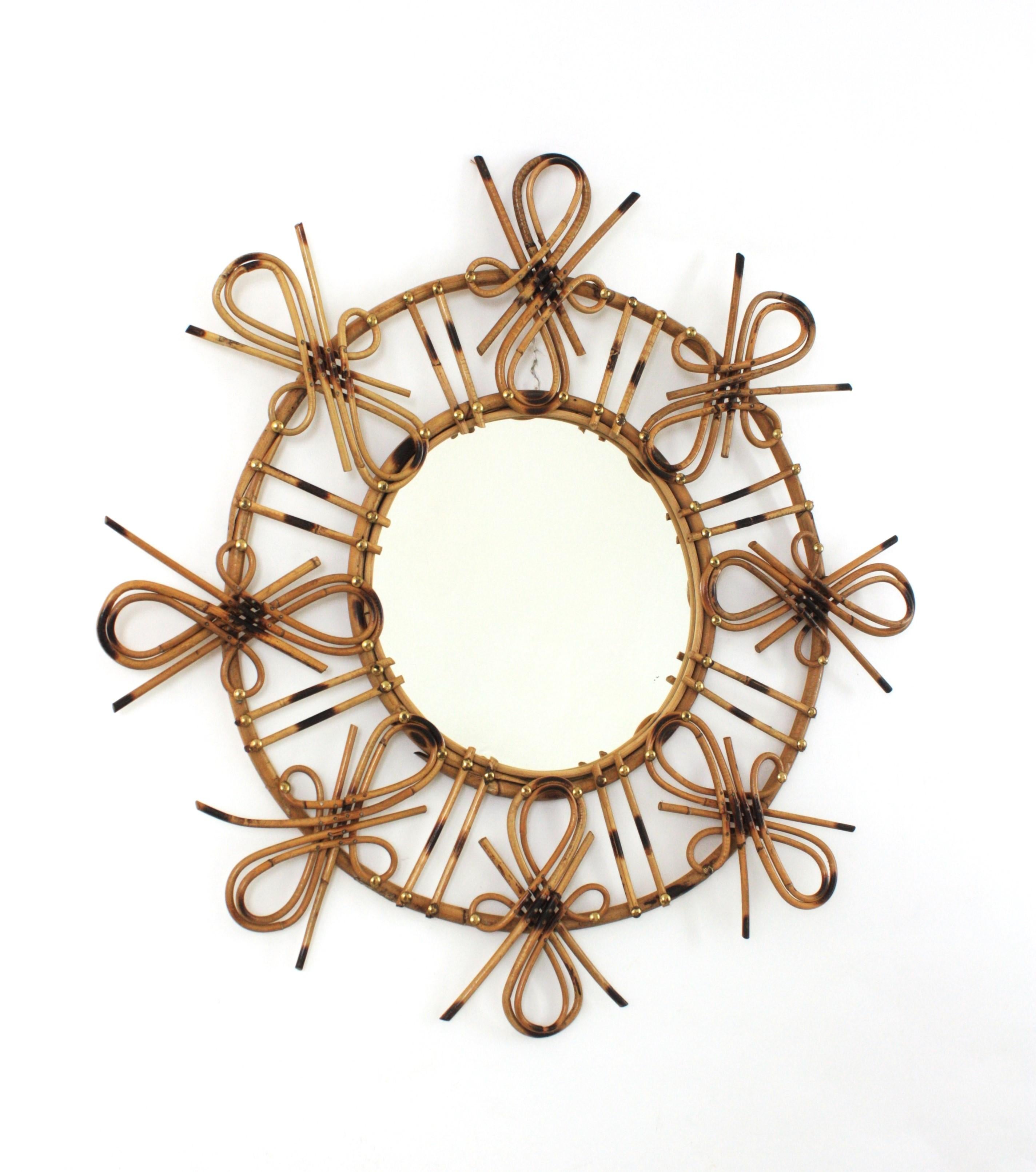 Specchio spagnolo Sunburst in rattan
Uno specchio altamente decorativo della metà del XX secolo realizzato a mano in rattan con decorazioni pirografiche e accenti cineseria o Tiki.
Spagna, 1950-1960.
Questo accattivante specchio a raggiera combina