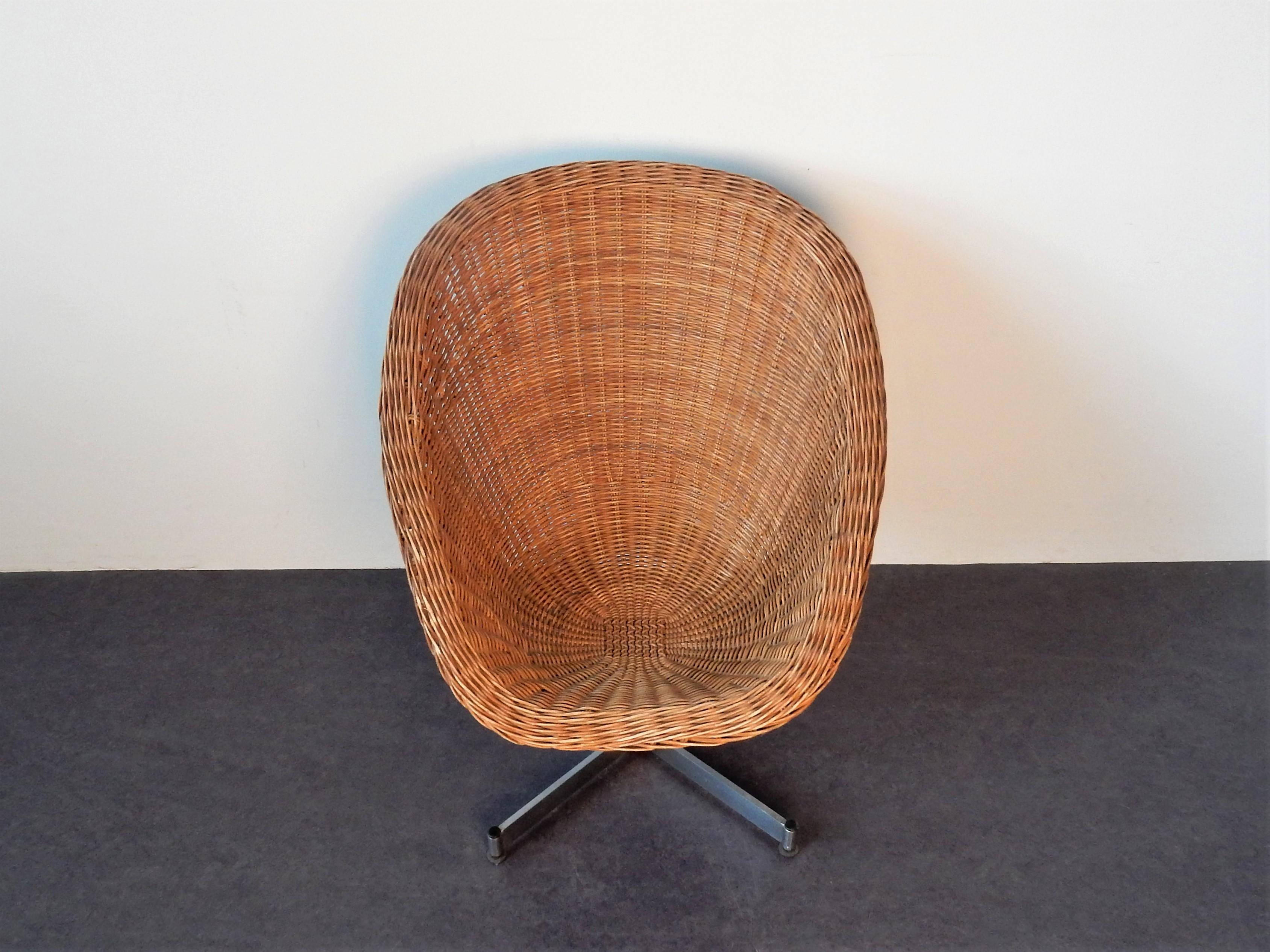 This rare rattan swivel chair was designed by Dirk van Sliedrecht for Gebroeders Jonkers. It has a chrome plated swivel base and a comfortable rattan seat. It is from the 1960s and has stood through time very well showing some signs of age and use.