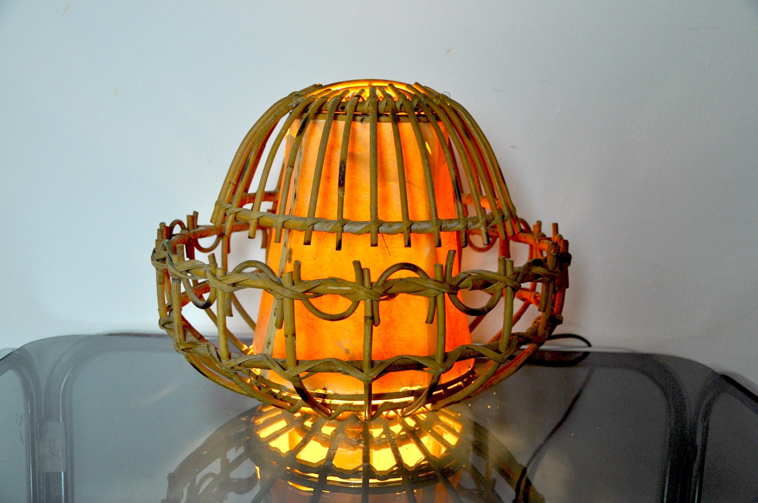 Très belle et atypique lampe de table en rotin conçue et produite en France dans les années 1960. Structure d'art populaire fabriquée à la main. Objet design unique qui illuminera merveilleusement votre intérieur. Électricité refaite, dommage sur