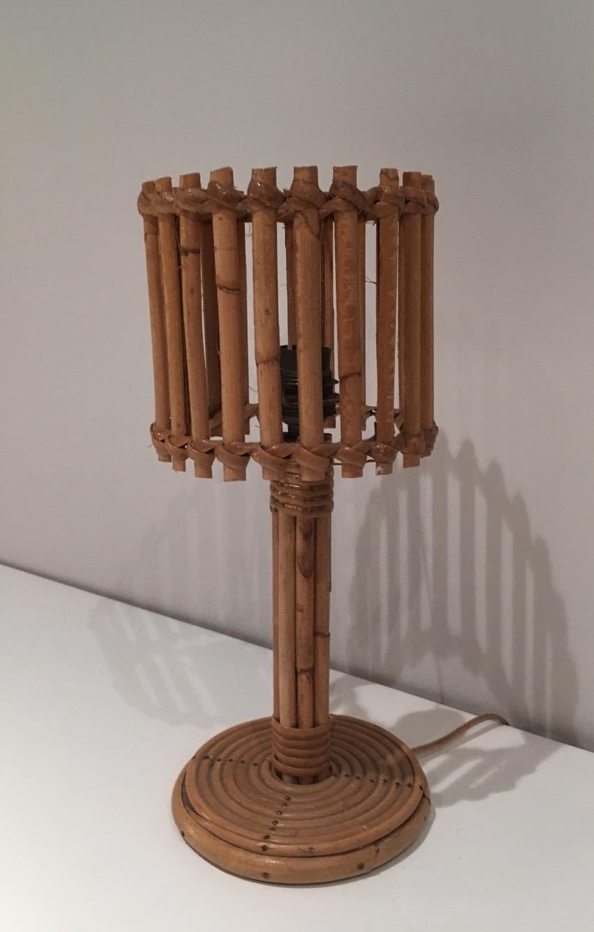 Diese Tischlampe ist aus Rattan gefertigt. Es handelt sich um ein französisches Werk im Stil von Audoux Minet. Um 1950