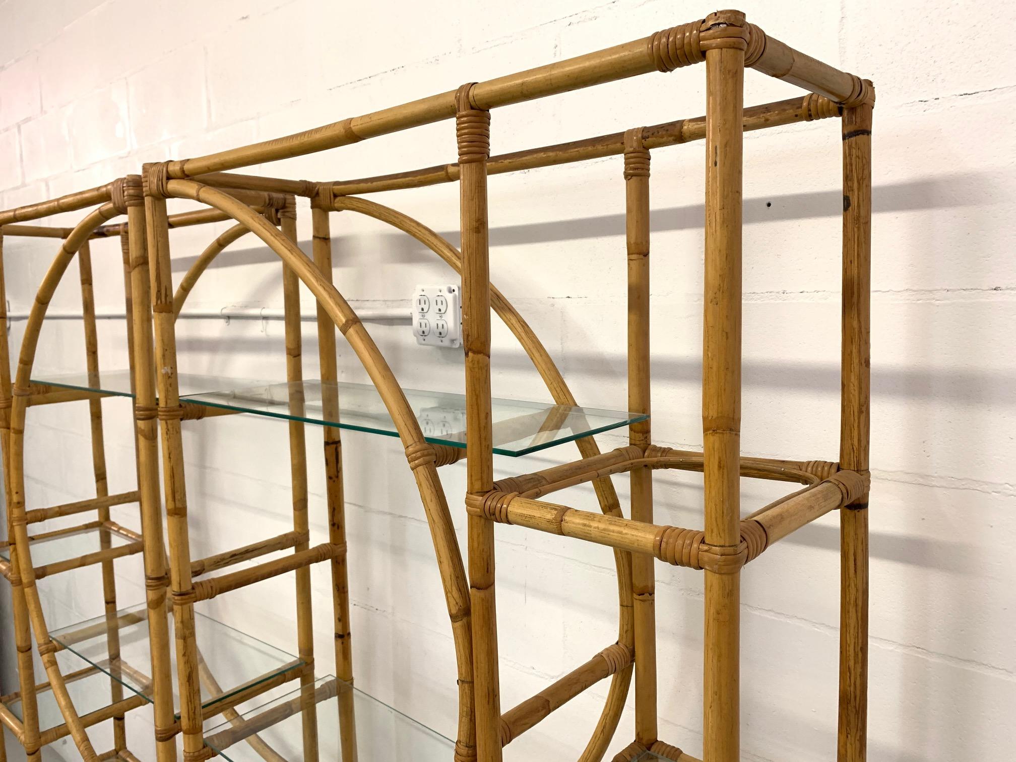 Pair of rattan étagères feature round center design and glass shelving, circa 1960s. Very good condition with very minor imperfections consistent with age. Each piece measures 36
