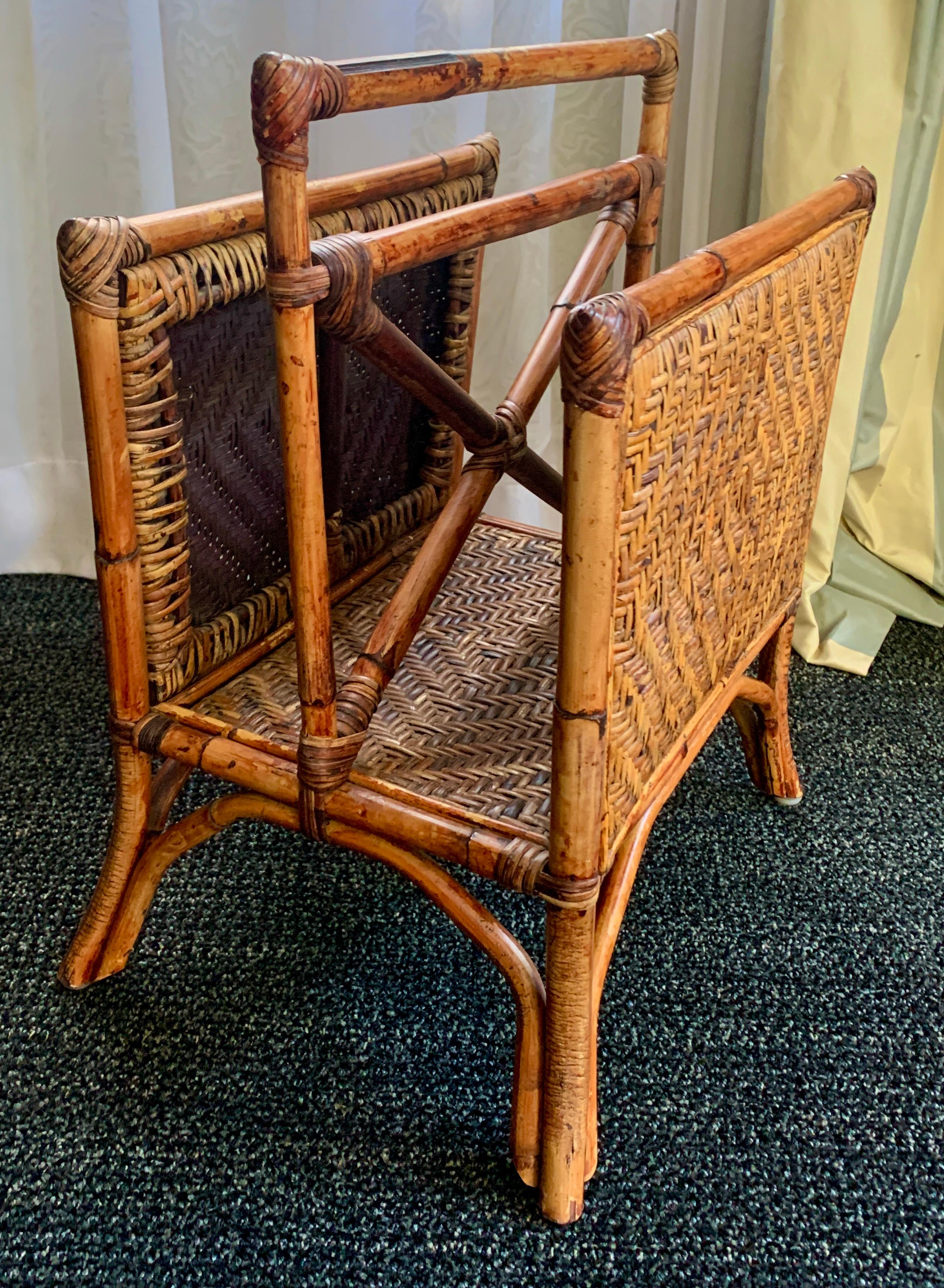 Rattan two section magazine rack. The construction and design are very nice, with a woven raffia/cane insert. The rack has two sides and designed in a way that create a handle for easy mobility. A vintage piece in wonderful condition. A compliment