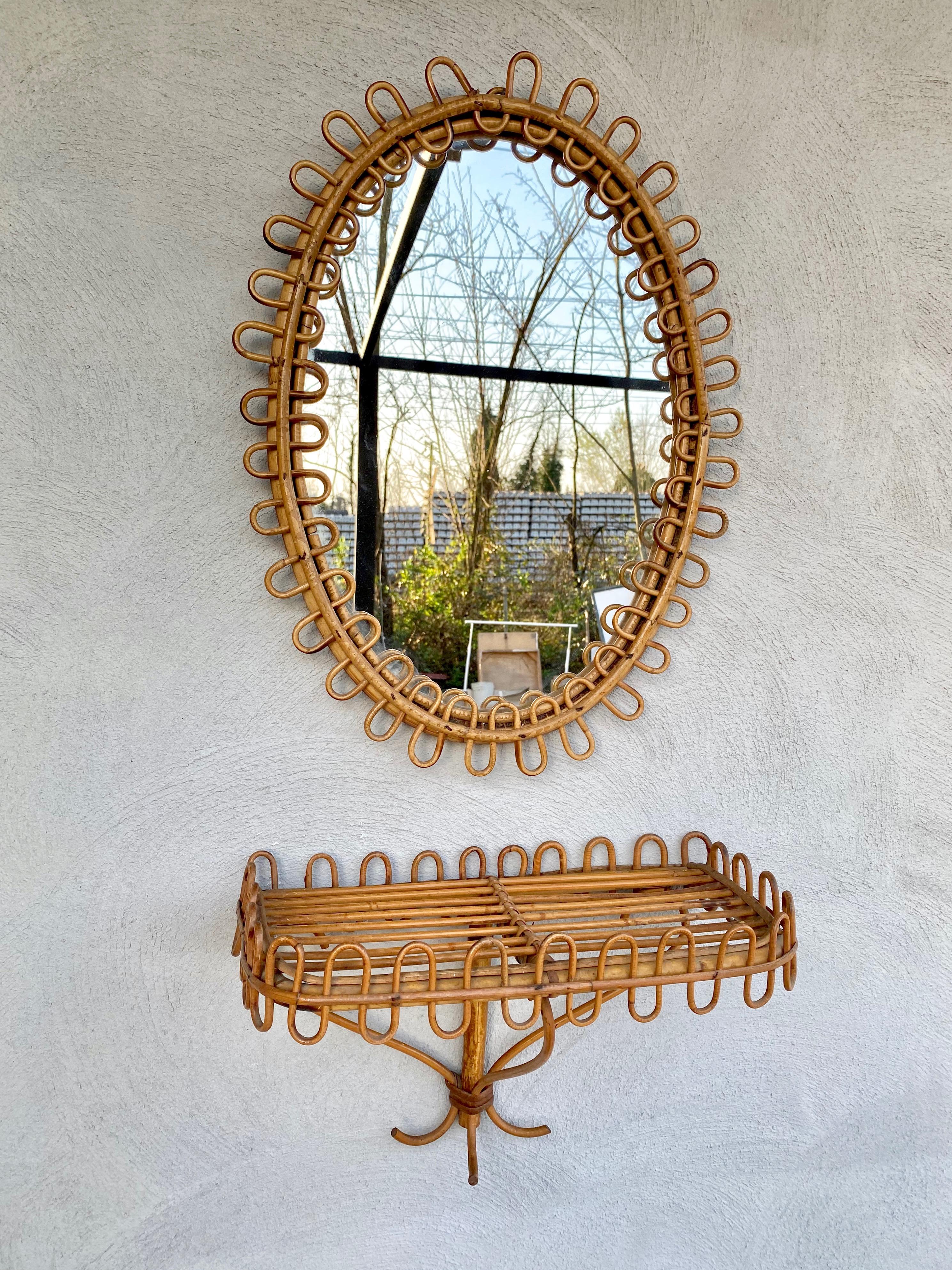 Rattan wall mirror and bedside wall-mounted table shelf by the Italian designer Franco Albini. Made in Italy, circa 1960.

Dimensions:
Mirror measures: height 57cm, width 41cm, depth 3cm.
Shelf measures: height 25cm, width 39cm, depth 22cm.