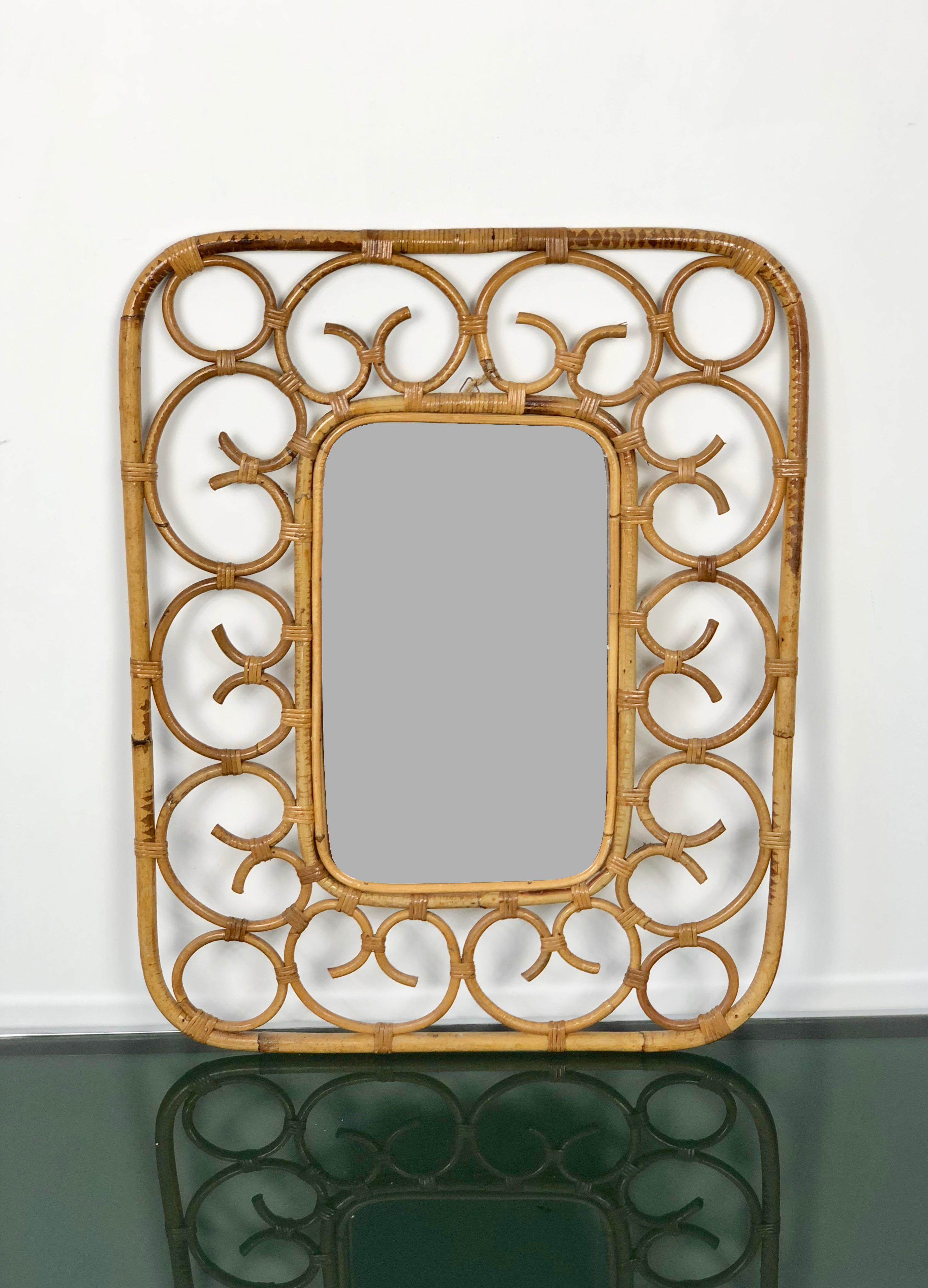 Wall mirror framed in rattan twirls in the style of the Italian designer Franco Albini, Italy, circa 1960.