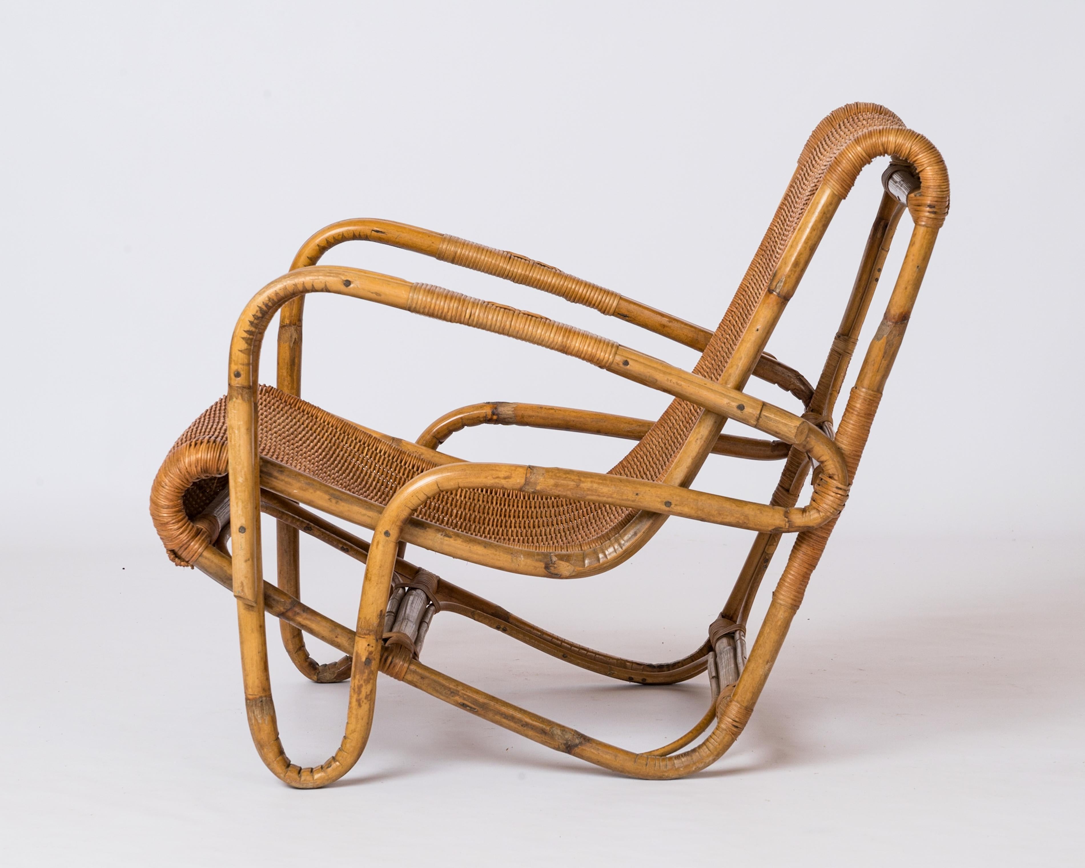 Fauteuil en rotin et en osier à structure unique en forme de boomerang inversé. France années 1950. Détails en osier tressé sur l'accoudoir. En bon état vintage. 
Cette chaise est expédiée depuis la France et peut être renvoyée soit en France, soit