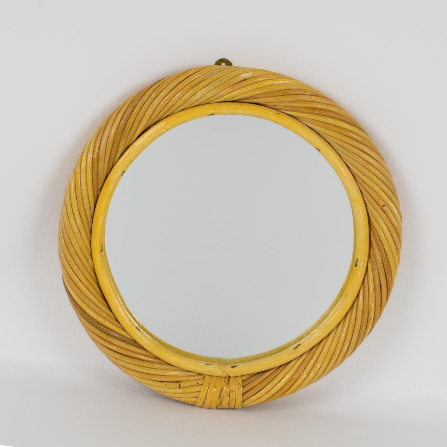 Questo delizioso specchio da parete italiano degli anni '60 è caratterizzato da un'intelaiatura arrotondata in vimini biondo intrecciato o rattan (bambù o canna da zucchero) con un inserto in vetro a specchio. Non è visibile il marchio del