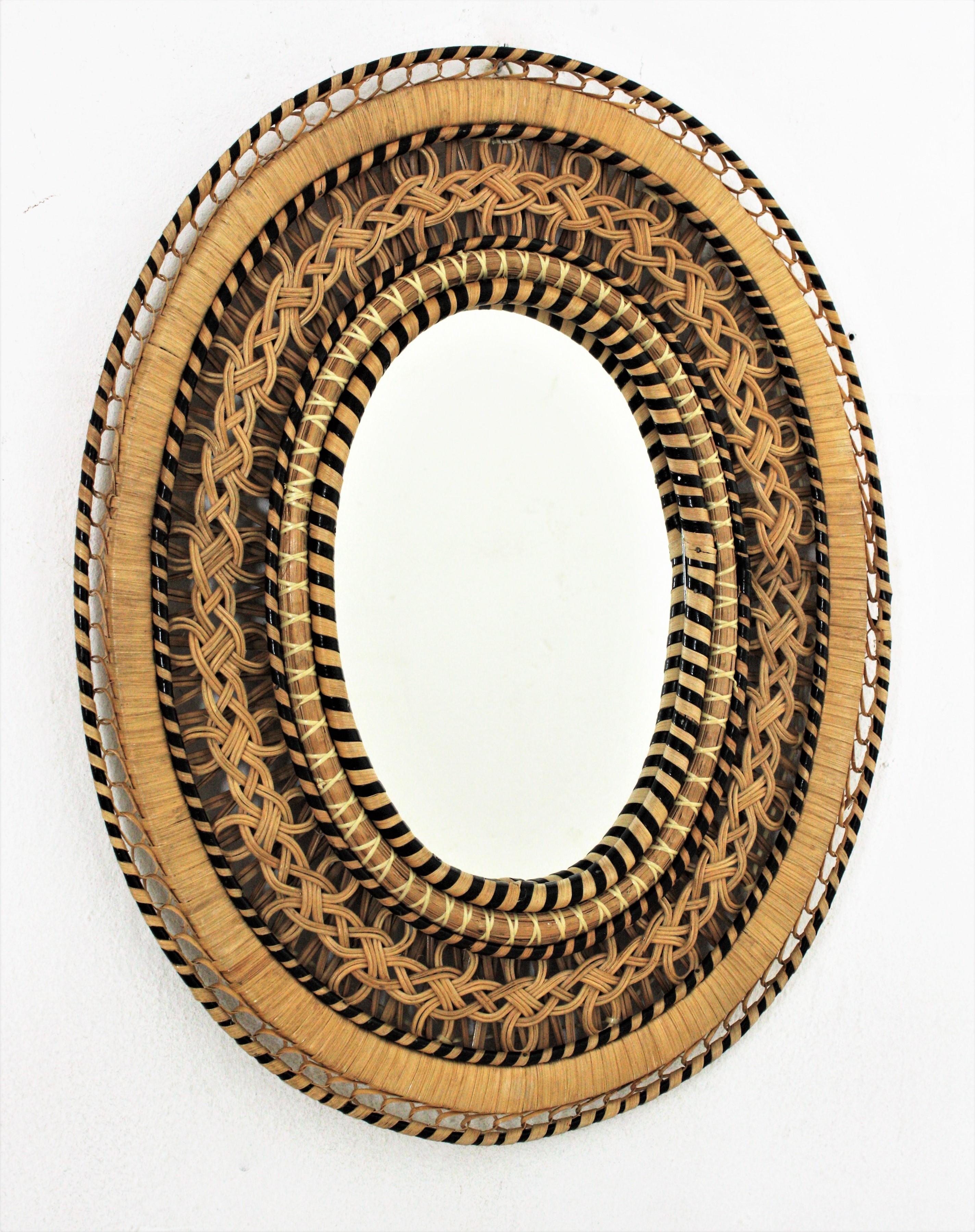 Peacock Emmanuelle Oval mirror, braided wicker, midcentury.
Spanish woven wicker and rattan oval shaped mirror, Spain, 1960s-1970s.
This mirror has a very detailded filigree handcrafted woven work combining nude color and black color creating a