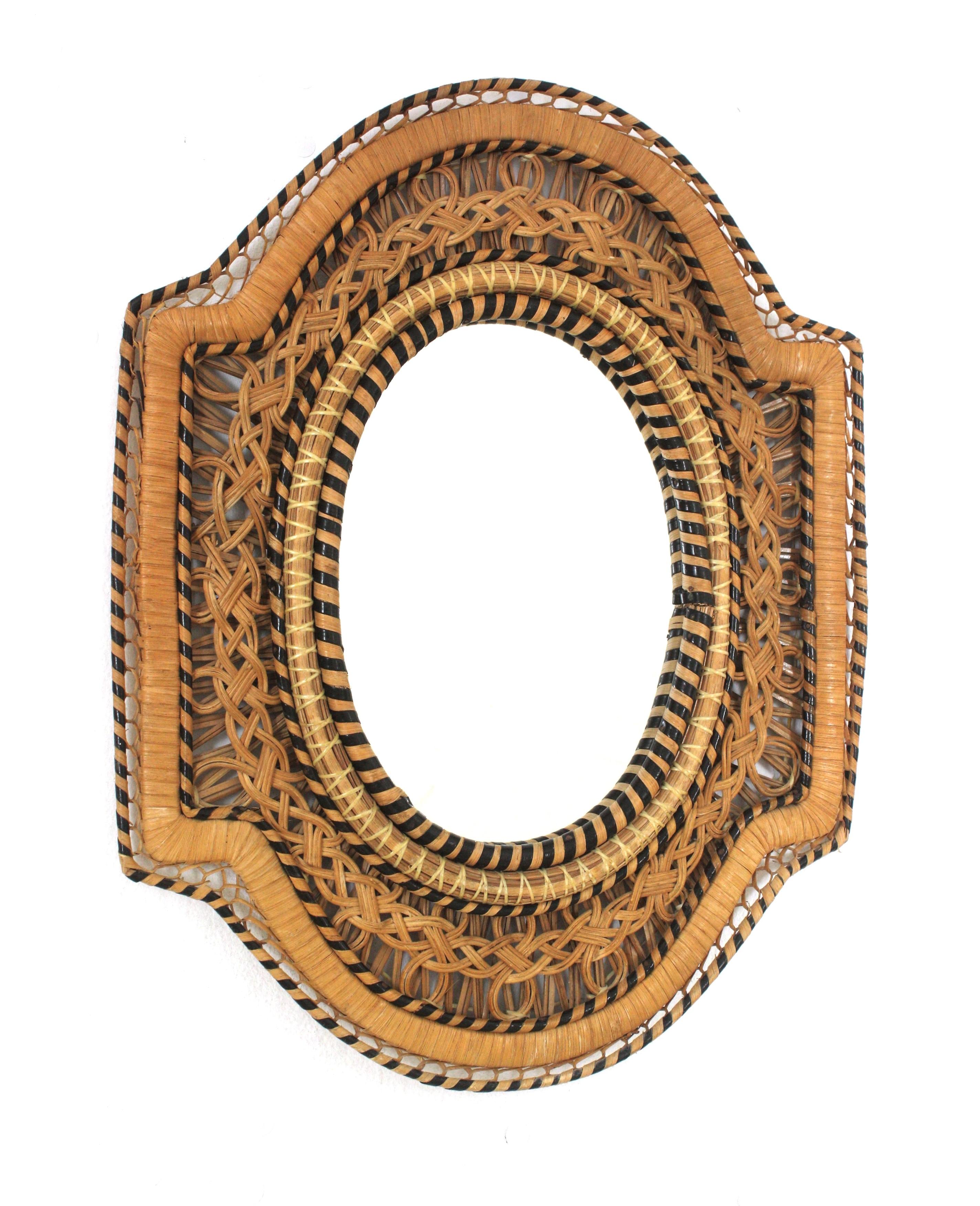 Specchio Midcentury in rattan intrecciato a mano in vimini Peacock, Spagna, anni '70
Raro da trovare.
Questo specchio accattivante è incorniciato da un intreccio di vimini e fibre naturali che combina diversi colori e crea un bellissimo effetto