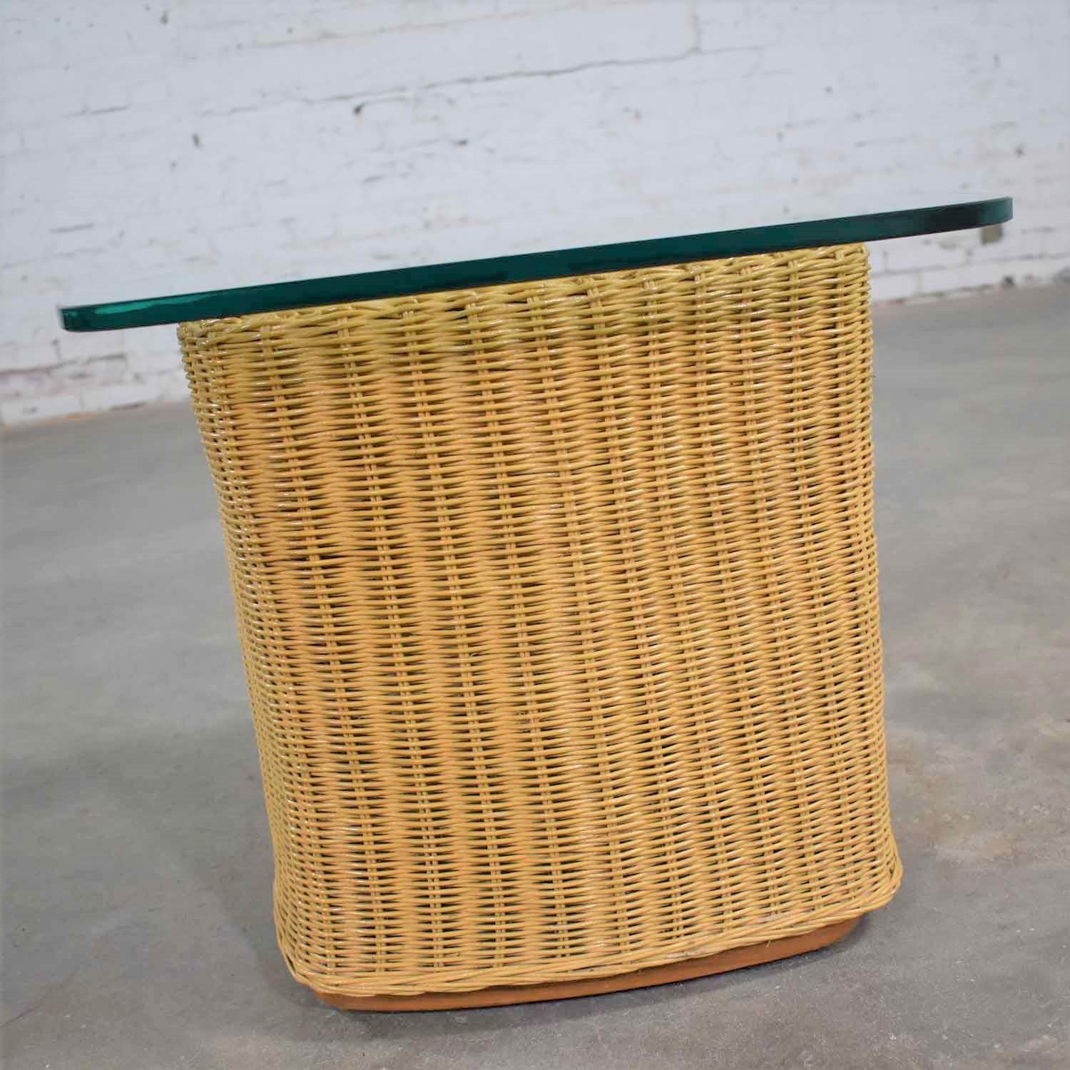Handsome organic modern rattan wicker side table or end table having a ½ inch thick glass top with an overhang. It is in very good vintage condition with no outstanding flaws we have detected. Please see photos, circa late 20th century.

We found