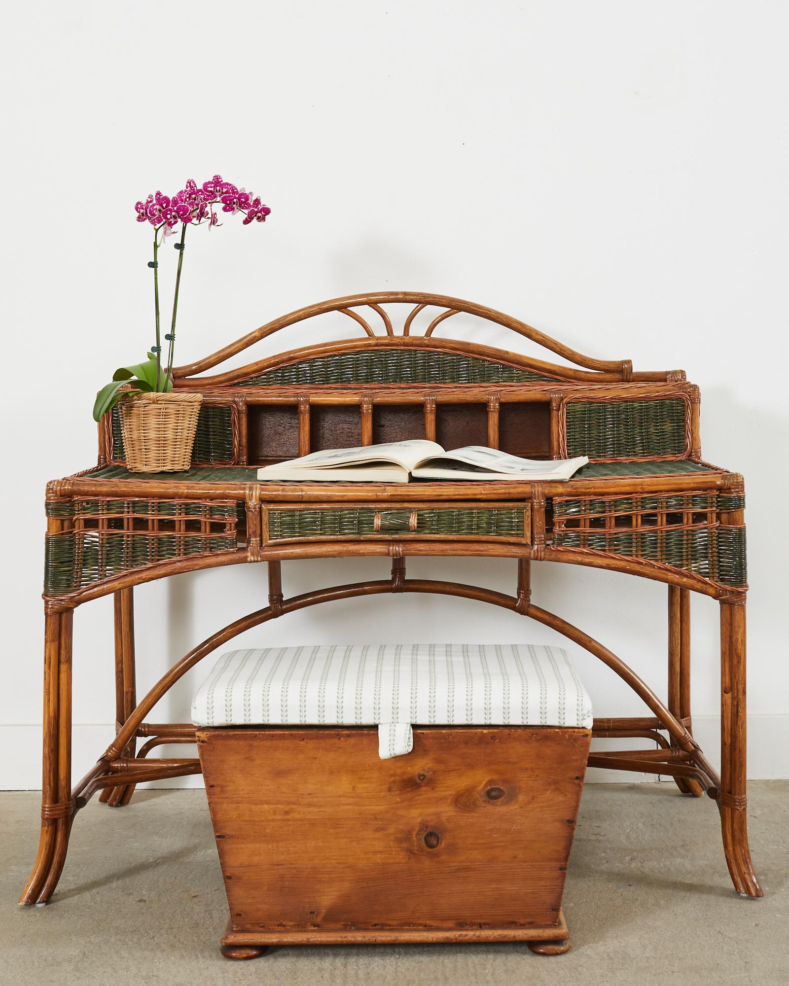 Amazing rattan and wicker writing table or desk attributed to Grange, France. The desk has a large rattan frame lashed together with rattan wicker peel laces. The writing surface measures 29 inches high and is completely covered in woven wicker