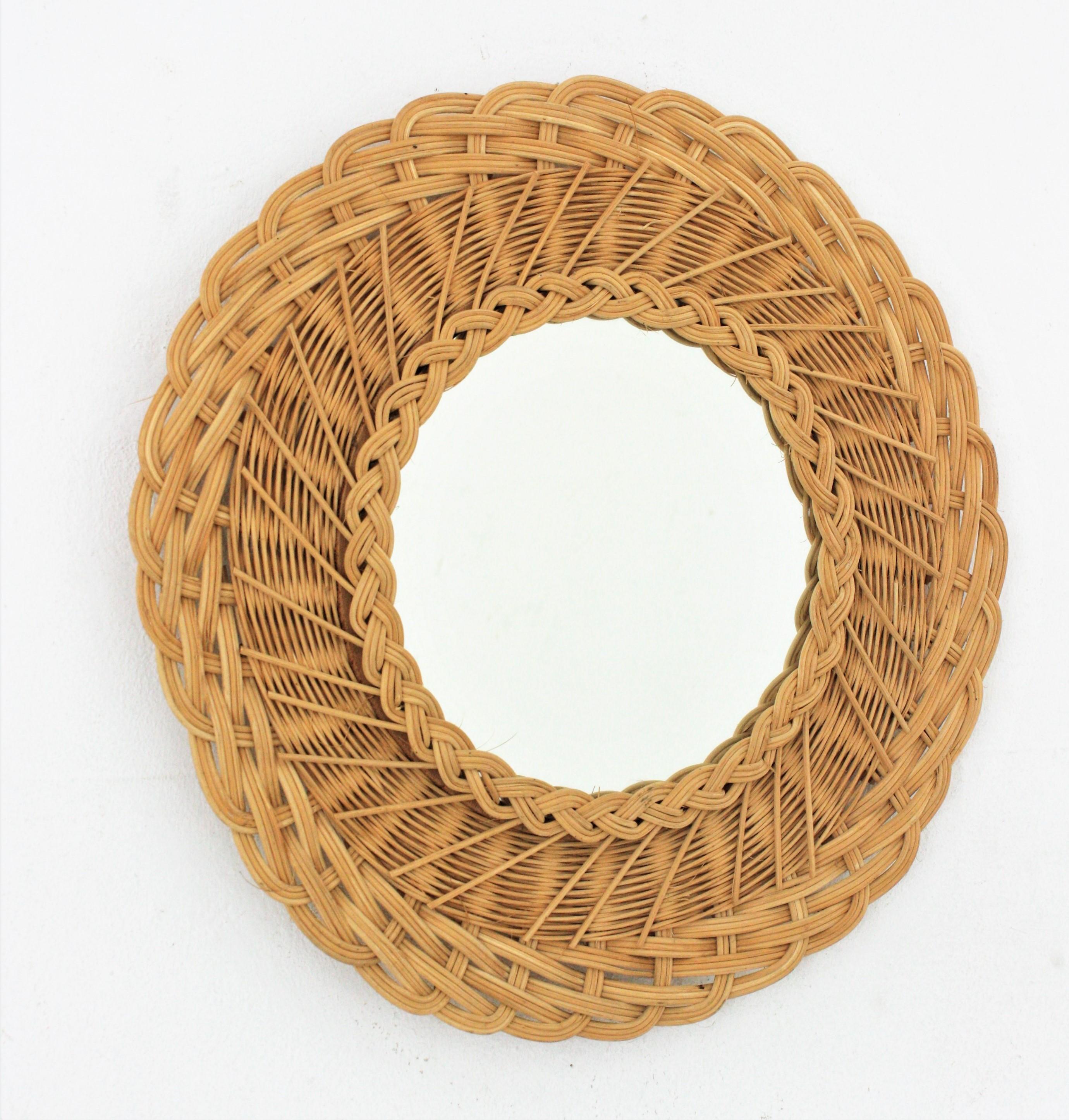 Eye-catchign round mirror handcrafted with woven wicker. Bohemian style, France, 1960s
Manufactured at the Mid-Century Modern period.
This mirror has a handcrafted braided work at the frame that makes it highly decorative and it has all the taste