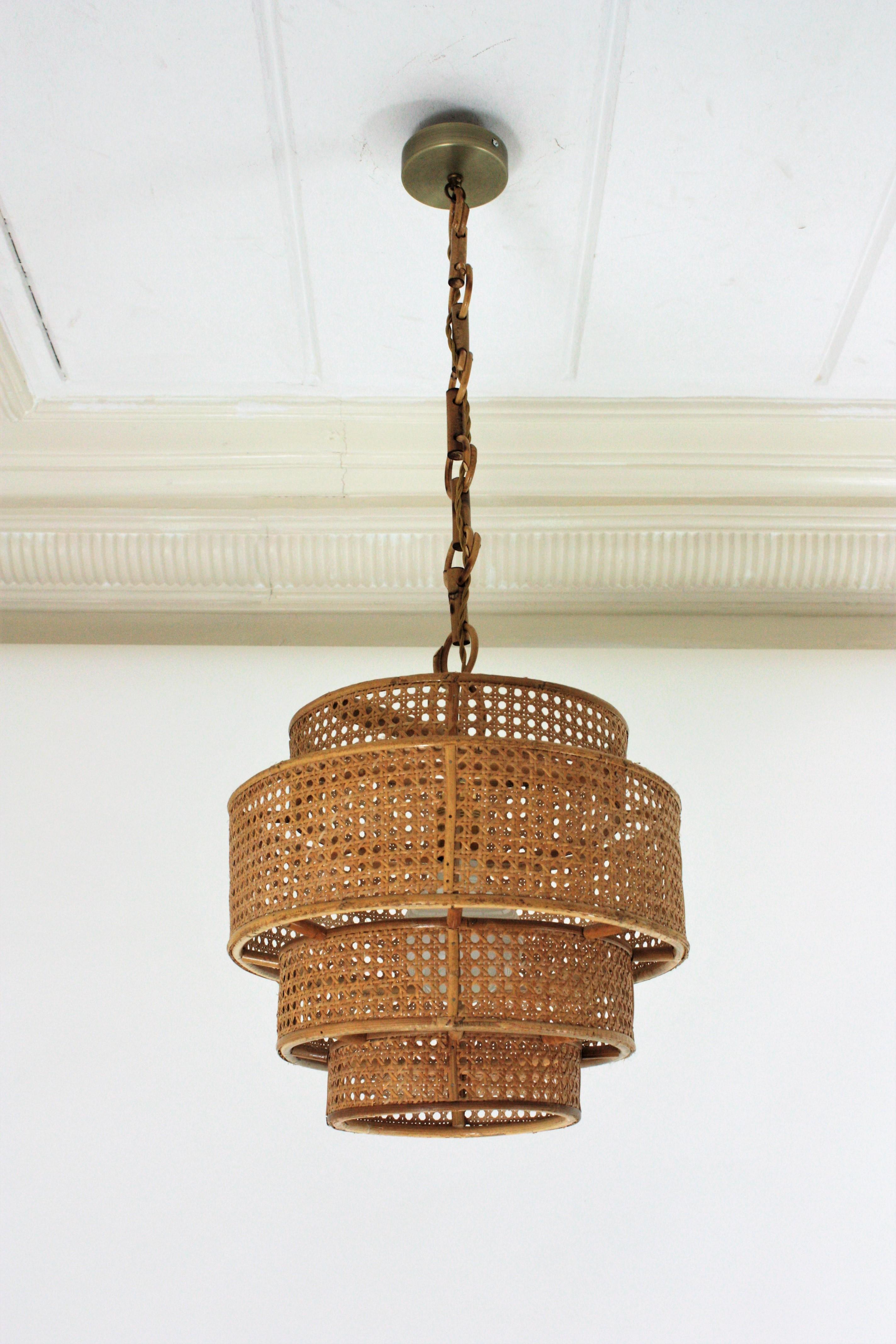 Eye-catching Mid-Century Modern cylinder rattan lantern or pendant ceiling lamp, Italy, 1960s.
This suspension features four concentric cylinders made rattan / wicker wire. The outer cylindrical shade is 34 cm diameter and the smaller inner rattan