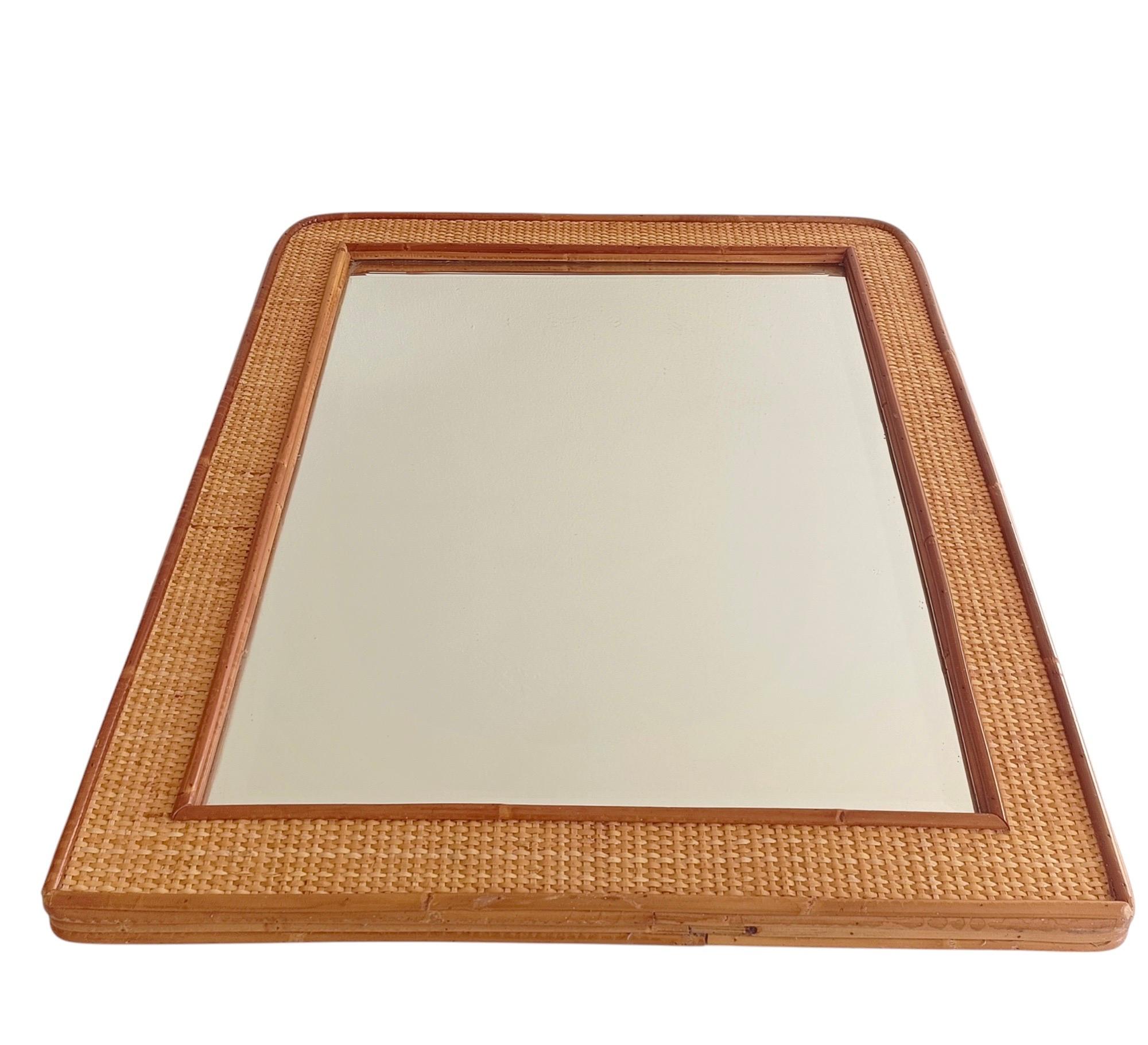 Grande specchio rettangolare in rattan e vimini, Italia, anni '70

Elegante specchio in vimini intrecciato e bambù della metà del secolo scorso. Questo pezzo italiano di alta qualità presenta una struttura in rattan scuro a tre strati con un centro