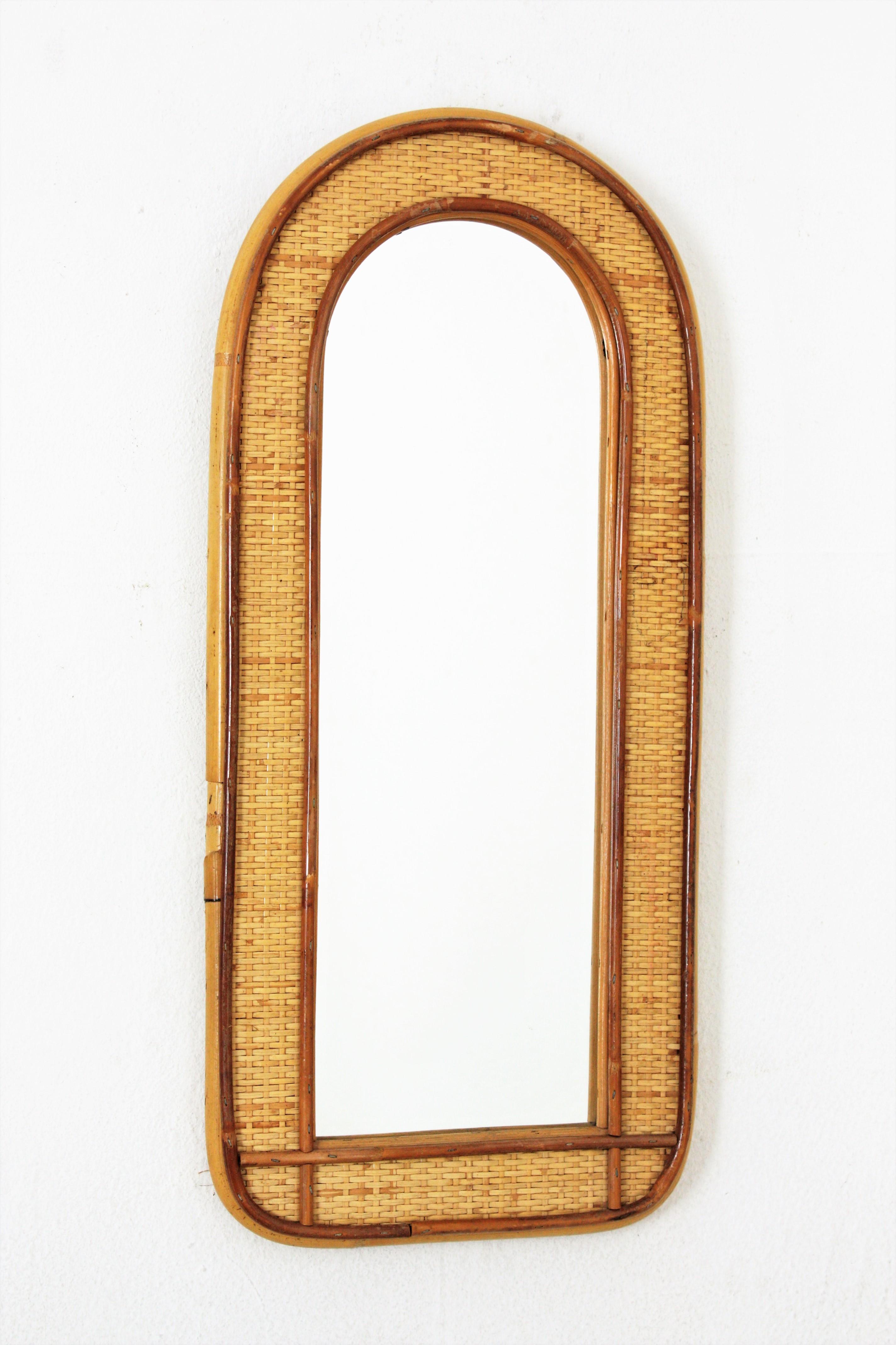 Gewölbter Spiegel aus Rattan und Weide, Italien, 1960-1970.
Eleganter Spiegel aus der Mitte des 20. Jahrhunderts aus geflochtener Weide und Bambus-Rattan mit gewölbtem Oberteil. 
Dieser schöne Spiegel mit doppeltem Rahmen aus Rattanrohr und