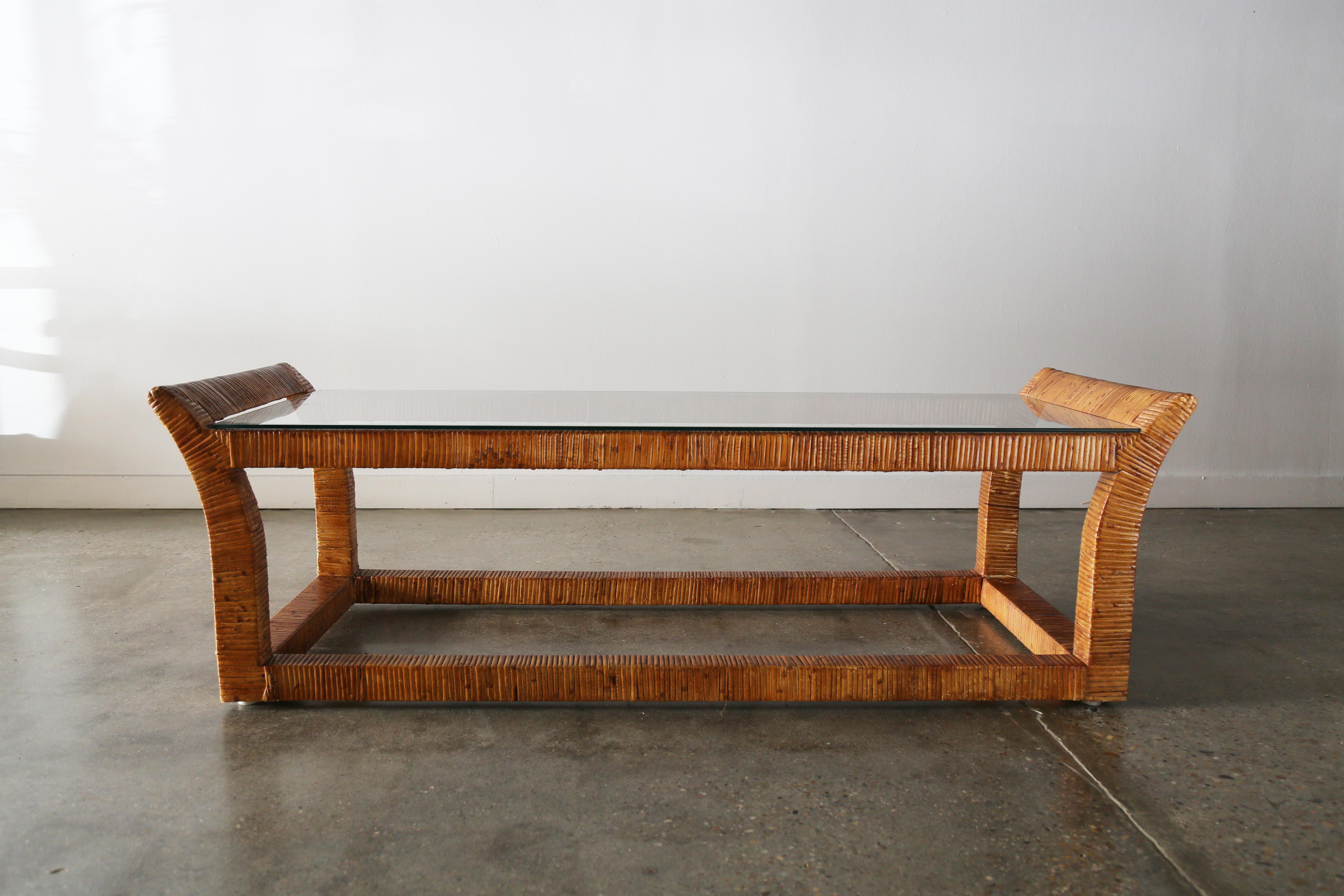A stylish coffee table consisting of a solid mahogany frame, wrapped completely in rattan. A thin glass top keeps the table visually light. The tapered flared ends provide interest to what would just be a rectangular form.

Similar styling to Danny