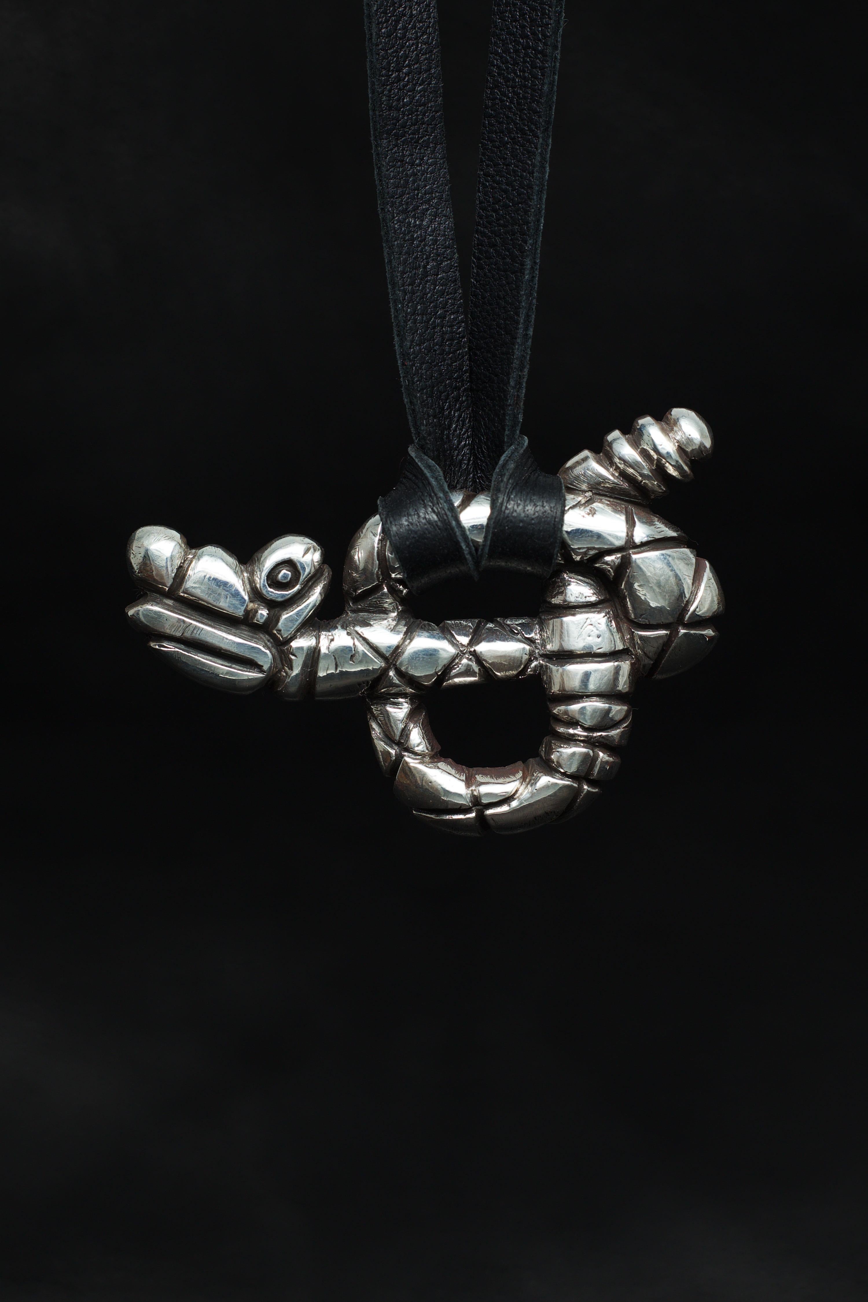 Der Rattlesnake-Anhänger von Ken Fury ist ein handgeschnitztes und gegossenes Stück, das die einzigartige Schönheit und Kraft dieser ikonischen nordamerikanischen Schlange einfängt. Mit seinen rautenförmigen Markierungen, dem gewundenen Körper und