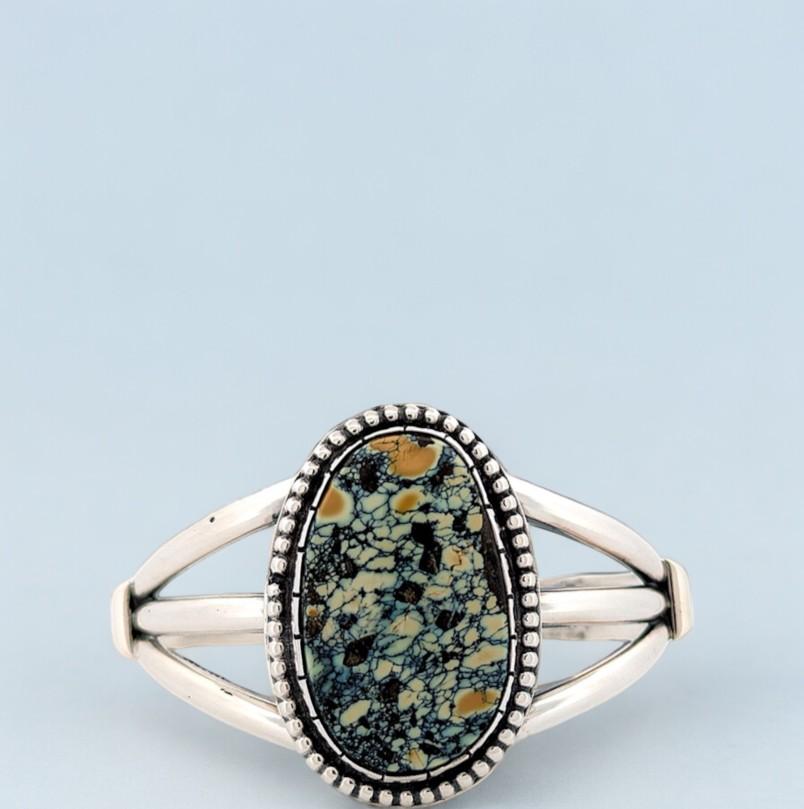 This exquisite cuff bracelet is a true masterpiece of Southwestern jewelry, handcrafted by the renowned artisan Rob Sherman. The sleek and modern sterling silver design provides a stunning backdrop for the vibrant New Lander turquoise, which shines