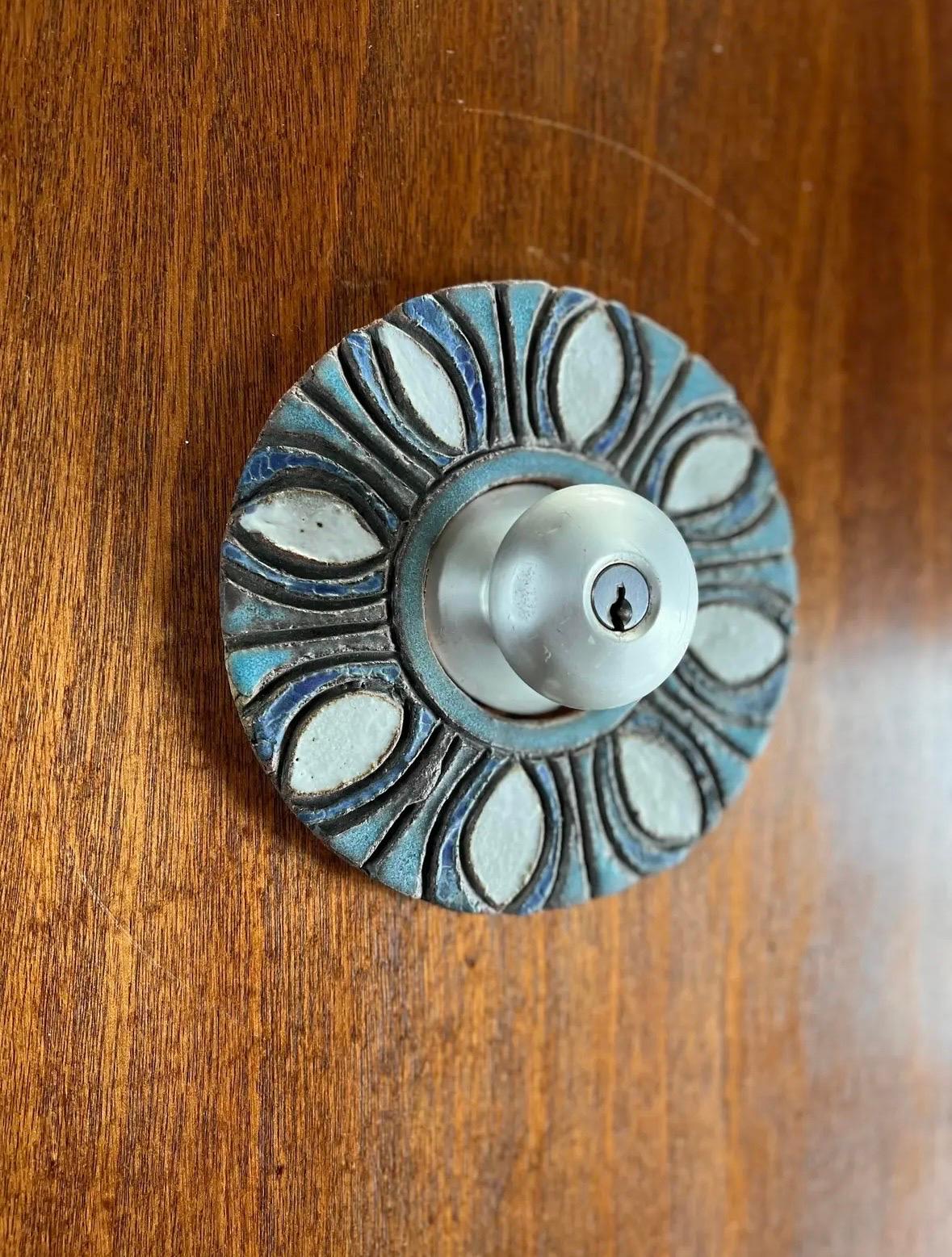 Unique & seldom seen ceramic door plate escutcheon by Raul Coronel. This piece was never used/installed. Center opening diameter measures 2-5/8” to fit around your existing door knob plate. Vintage hardware not included in listing.

Shipping from