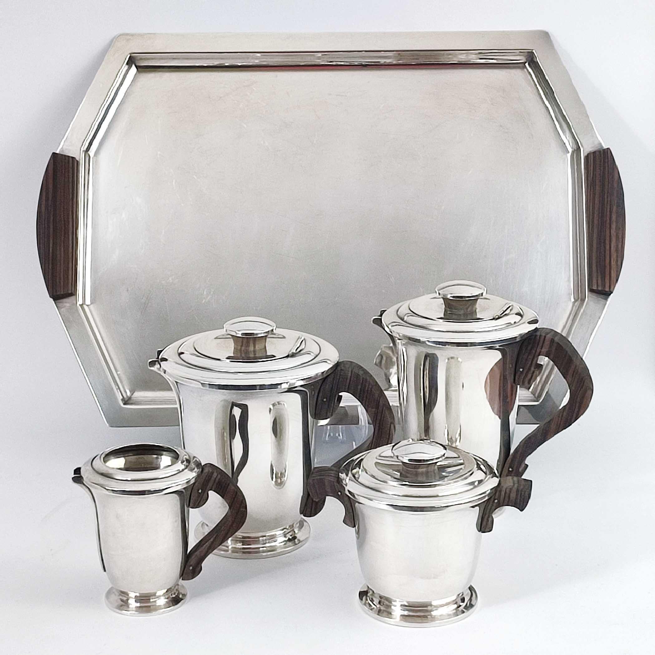 Ravinet d'Enfert, France, circa 1930.
Art Deco French Silver Plate and Ebony 5 piece Tea & Coffee set with matching tray. Includes a teapot with hinged cover, a coffee pot with hinged cover, a cream jug, a sugar bowl with cover and a matching