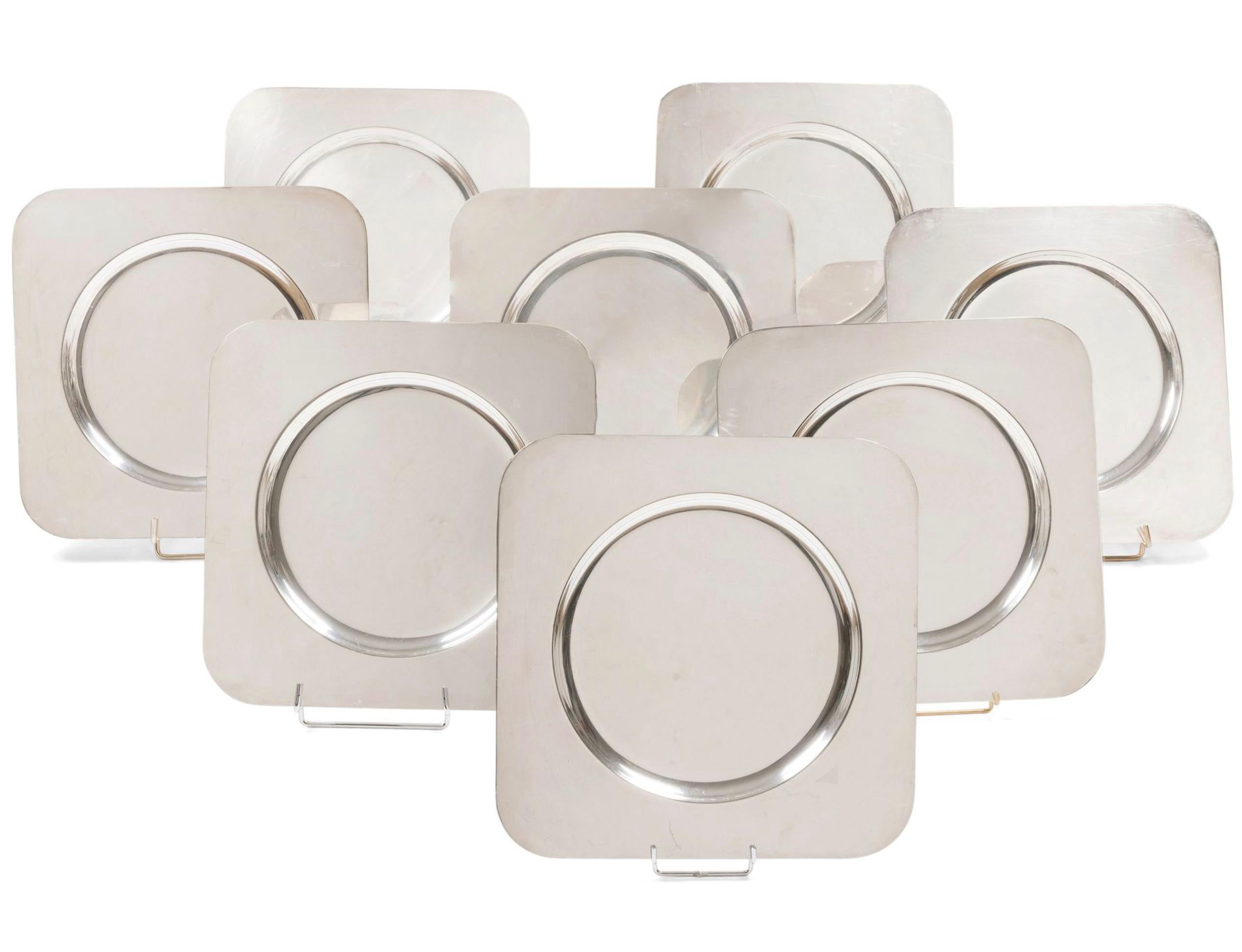 RAVINET-DENFERT ORFÈVRE circa 1960 

Suite of 6 square presentation plates with rounded corners and circular hollow centers. 
Polished nickel silver proofs.

 Each piece marked RAVINET-DENFERT Maillechort on the reverse. 
Side Length: 33 cm 