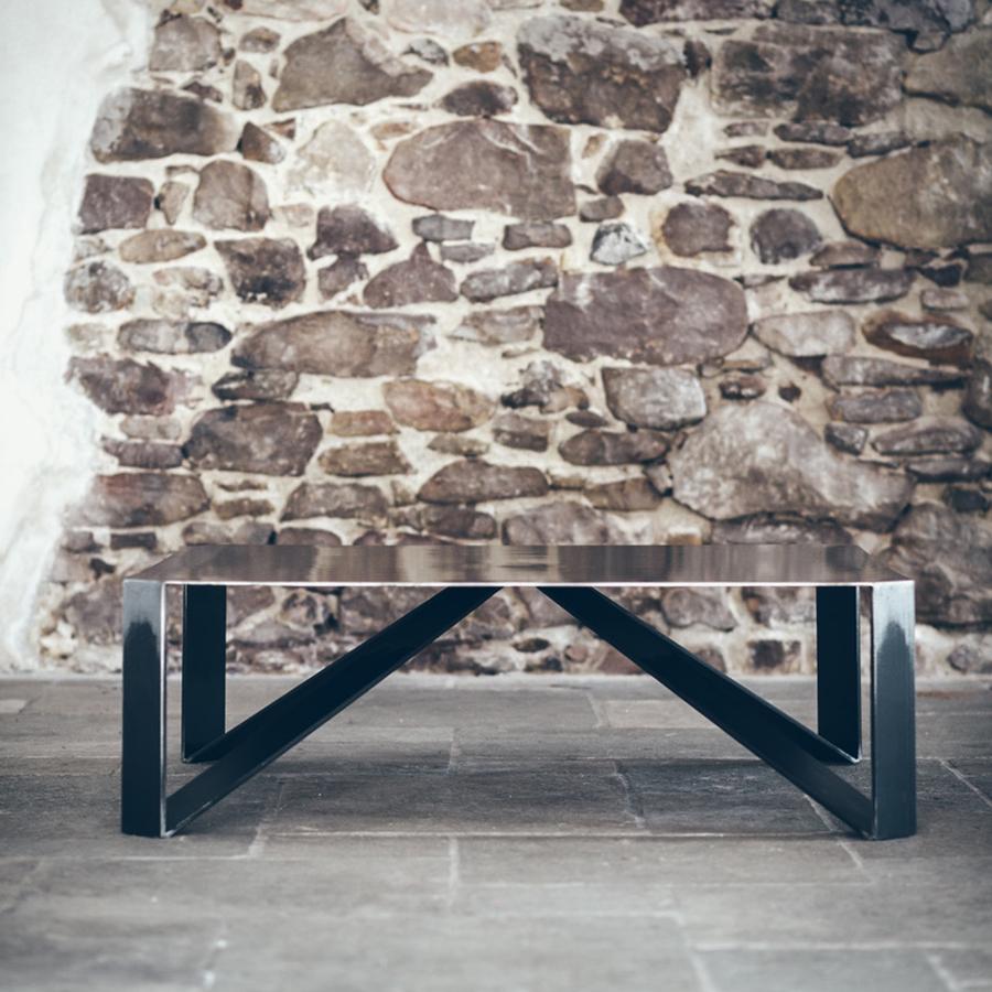 Table basse aux angles bruts en fabrication artisanale
en acier, en finition foncée. Fabriqué en français.