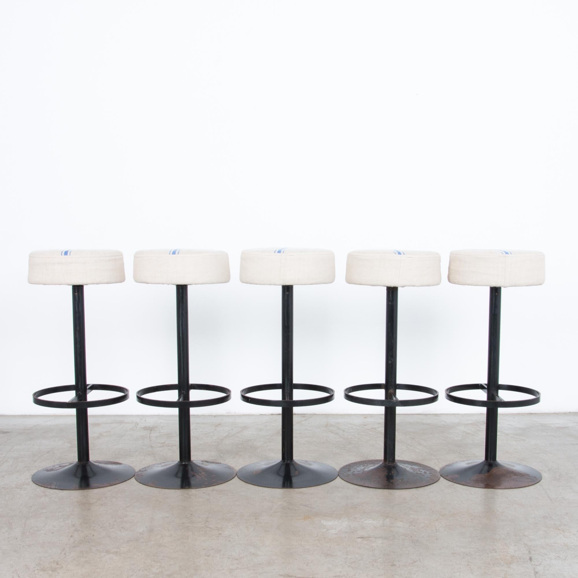 From 1970s Belgium, six sleek steel stools with a minimal designed base topped with a blue striped fabric seat. Oxidised black enamel, updated and polished with unique upholstered tops cut from vintage patterned linen.