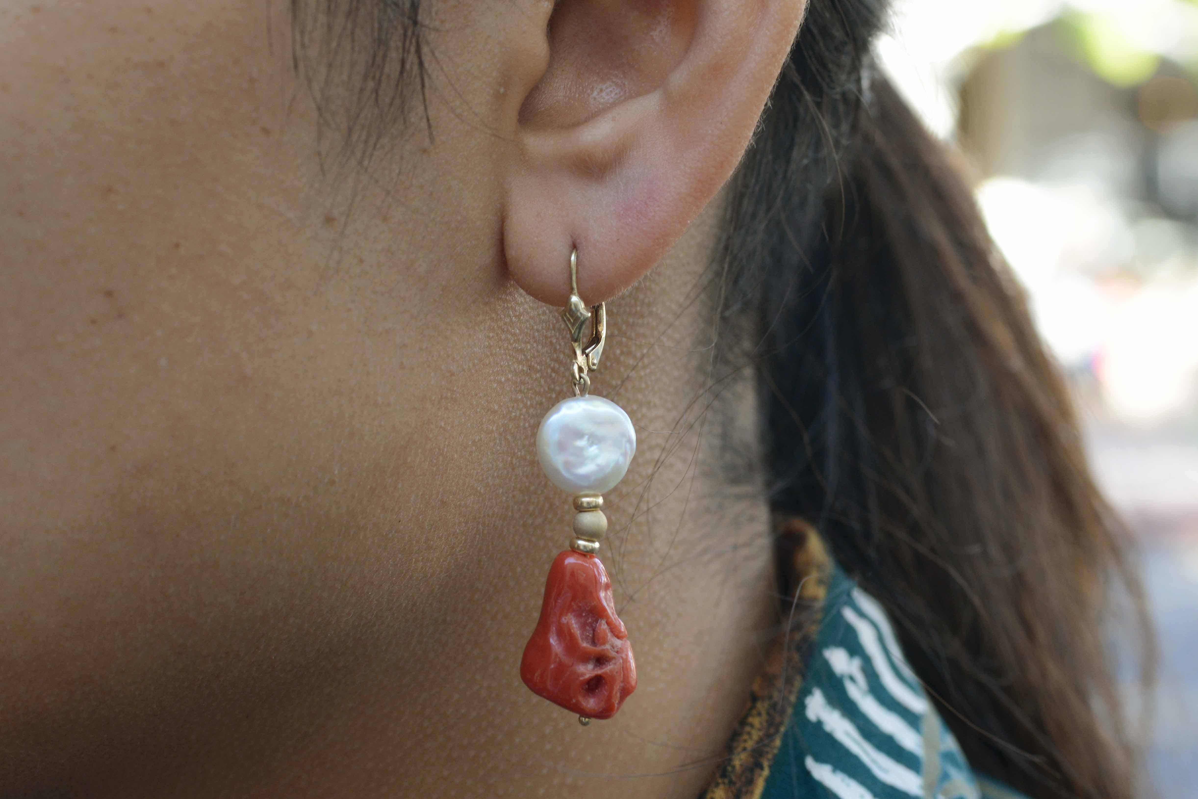 These raw red coral and pearl dangle earrings are quite fashionable. The drop style allows for a seductive movement that really captures your attention. The luscious color of the coral nuggets, left in their natural shapes have been polished to a