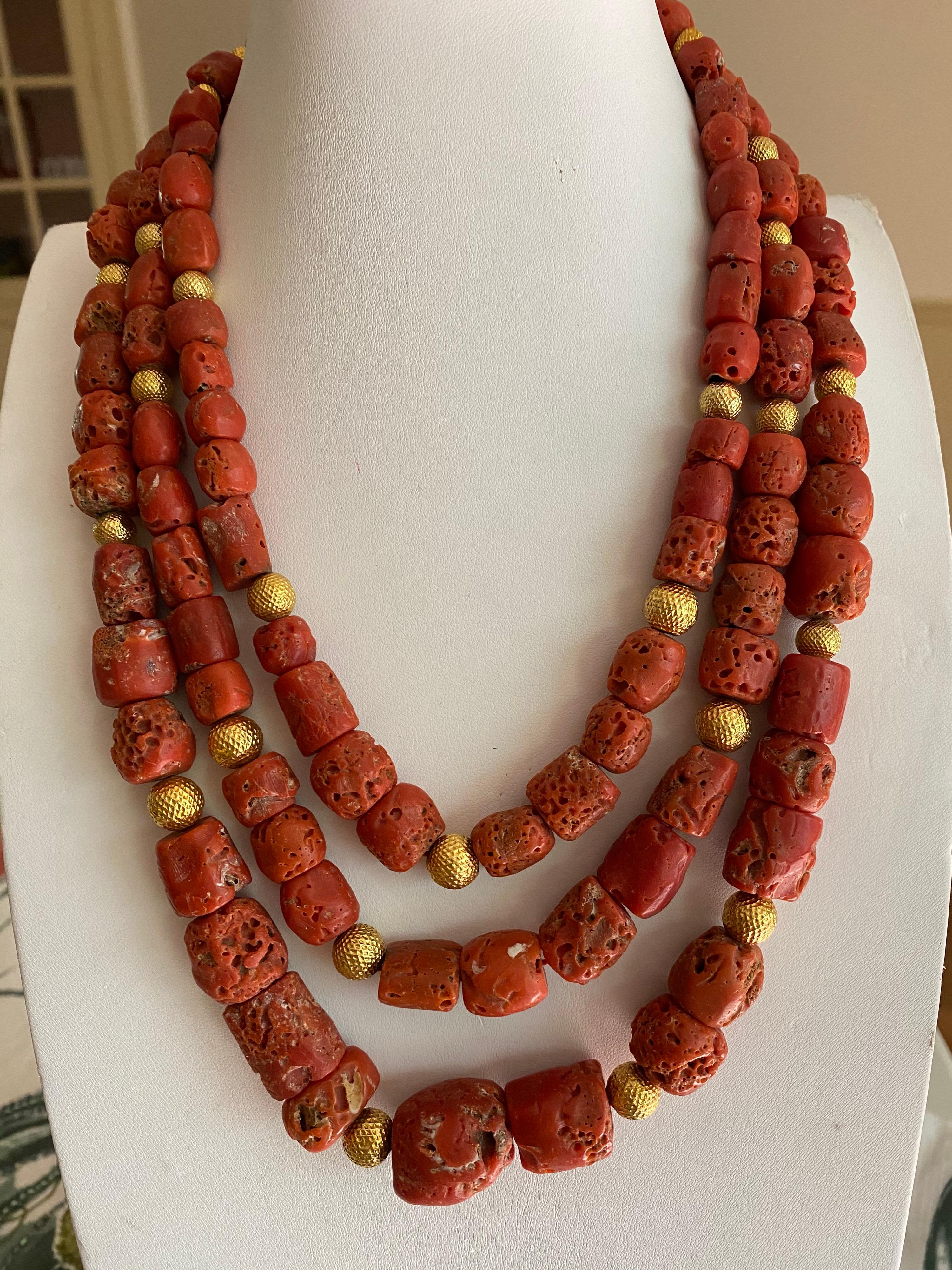 Jane Magon Collections Warrior Woman Red Coral Chunky 3 strand necklace with an easy clip clasp is a fashion staple for any woman's closet. These natural colored Red Coral are warming to the skin and the gold plated balls give it warmth and balance.
