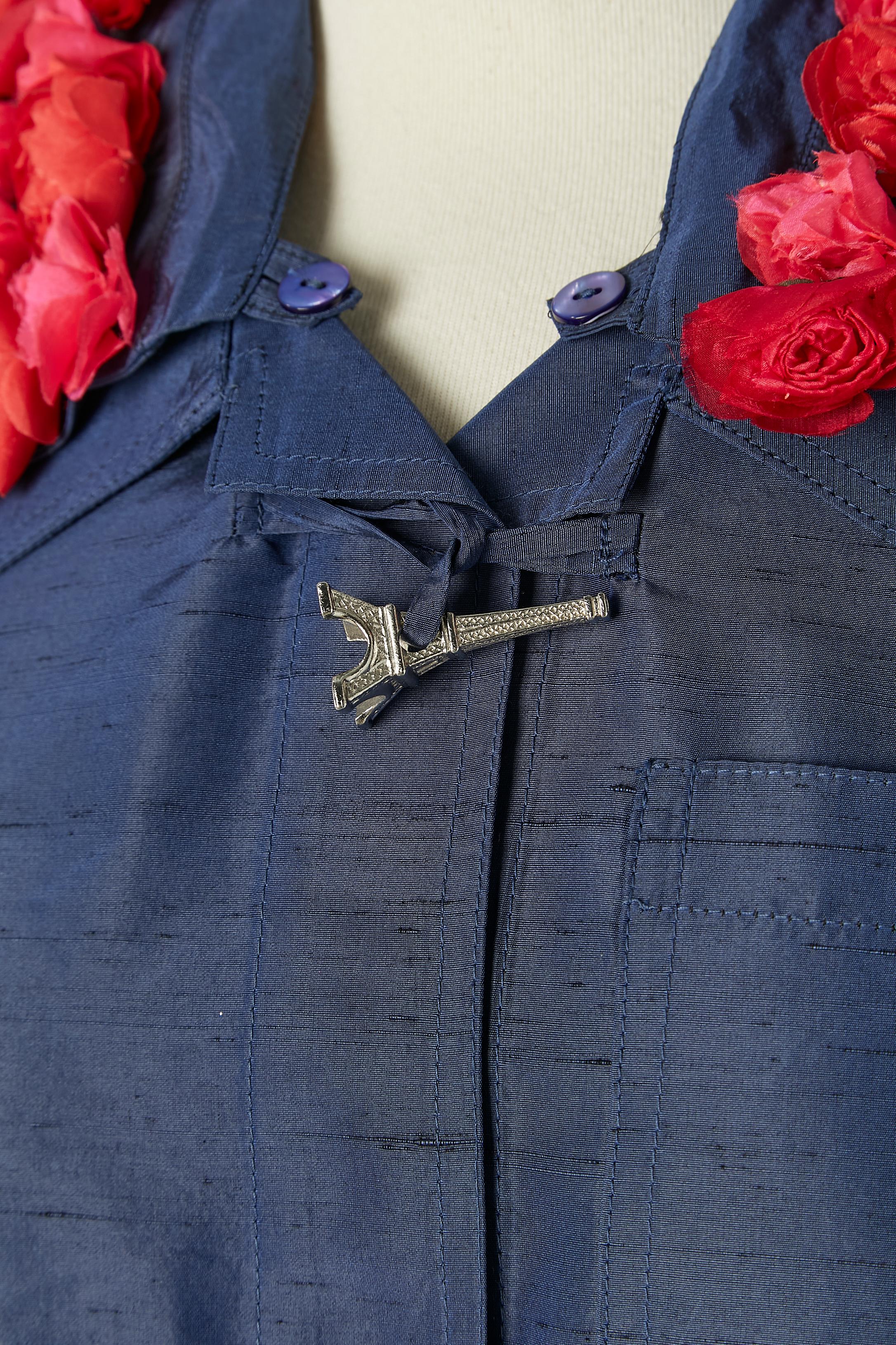 Giacca blu in seta grezza con colletto a rose e bottone della Torre Eiffel. Colletto staccabile con bottone e asola. Tasca su entrambi i lati + una tasca sul petto. Mezza cintura sulla schiena con bottone automatico. 
TAGLIA 38 / M 