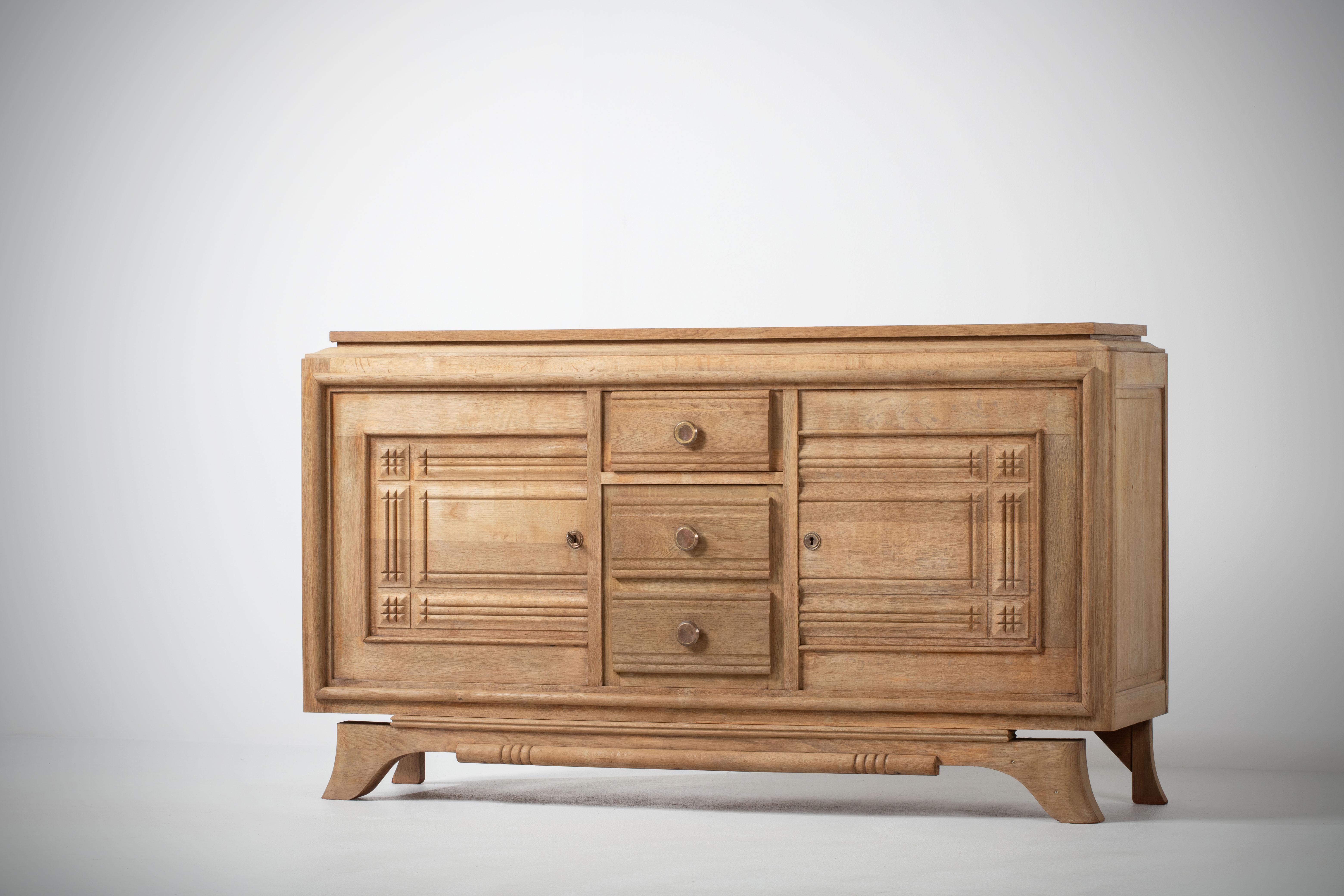 Credenza, solid oak, France, 1940s
Art Deco Brutalist sideboard. 
The credenza consists of two storage facilities and covered with very detailed designed doors and in the center, a drawers column.
     