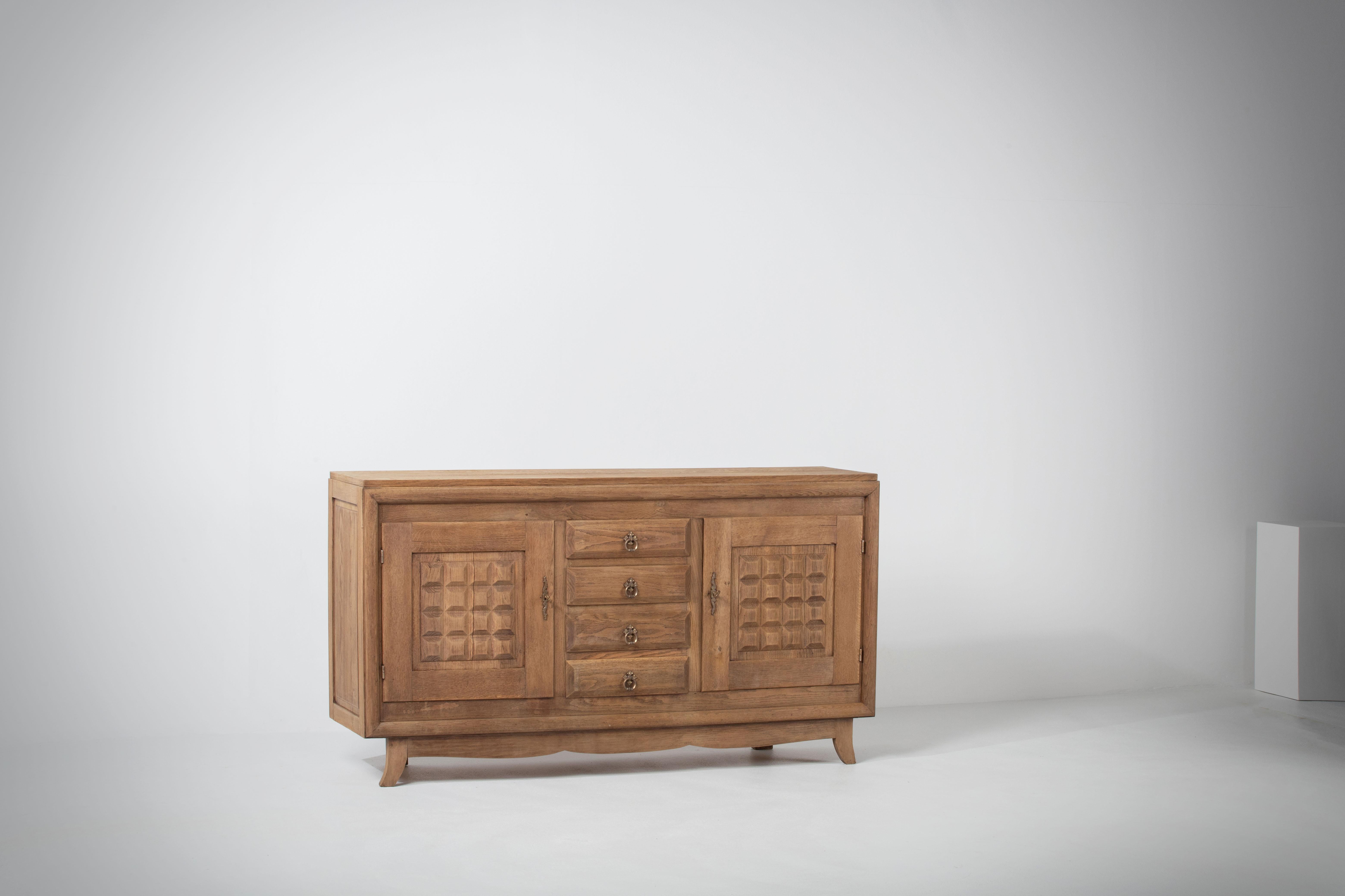 Anrichte, Eiche massiv, Frankreich, 1940er Jahre
Brutalistisches Sideboard im Art-Deco-Stil. 
Die Kredenz besteht aus zwei Ablagemöglichkeiten und ist mit sehr detailliert gestalteten Türen und in der Mitte mit einer Schubladensäule versehen.
 