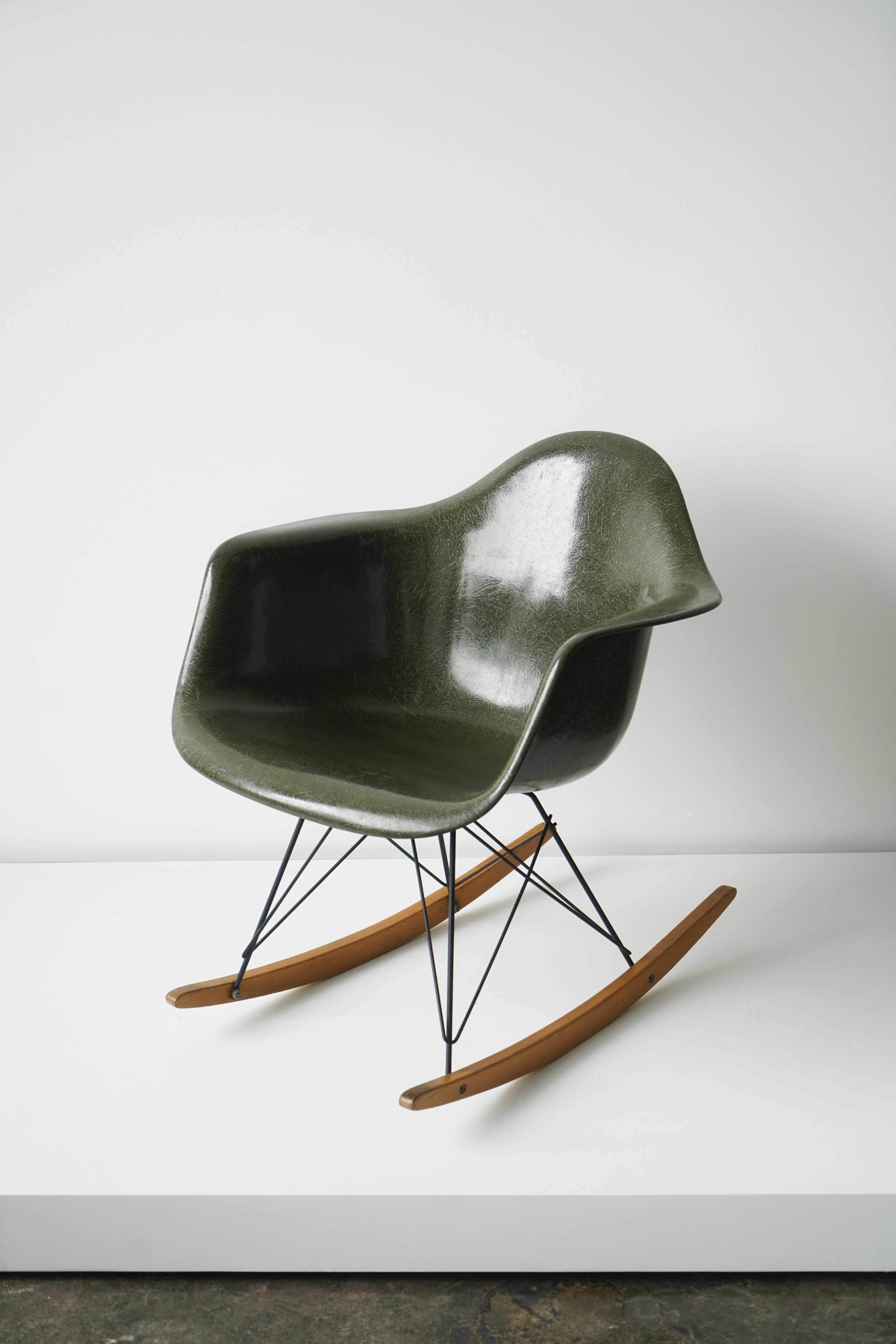 Ray and Charles Eames RAR rocking chair for Herman Miller
Circa 1965
Molded fiberglass seat in forest green. Birch runners.

Molded manufacturer's mark to underside. 

The famous Eames Rocking (R) Arm (A) Chair on Rod (R) Base, abbreviated to