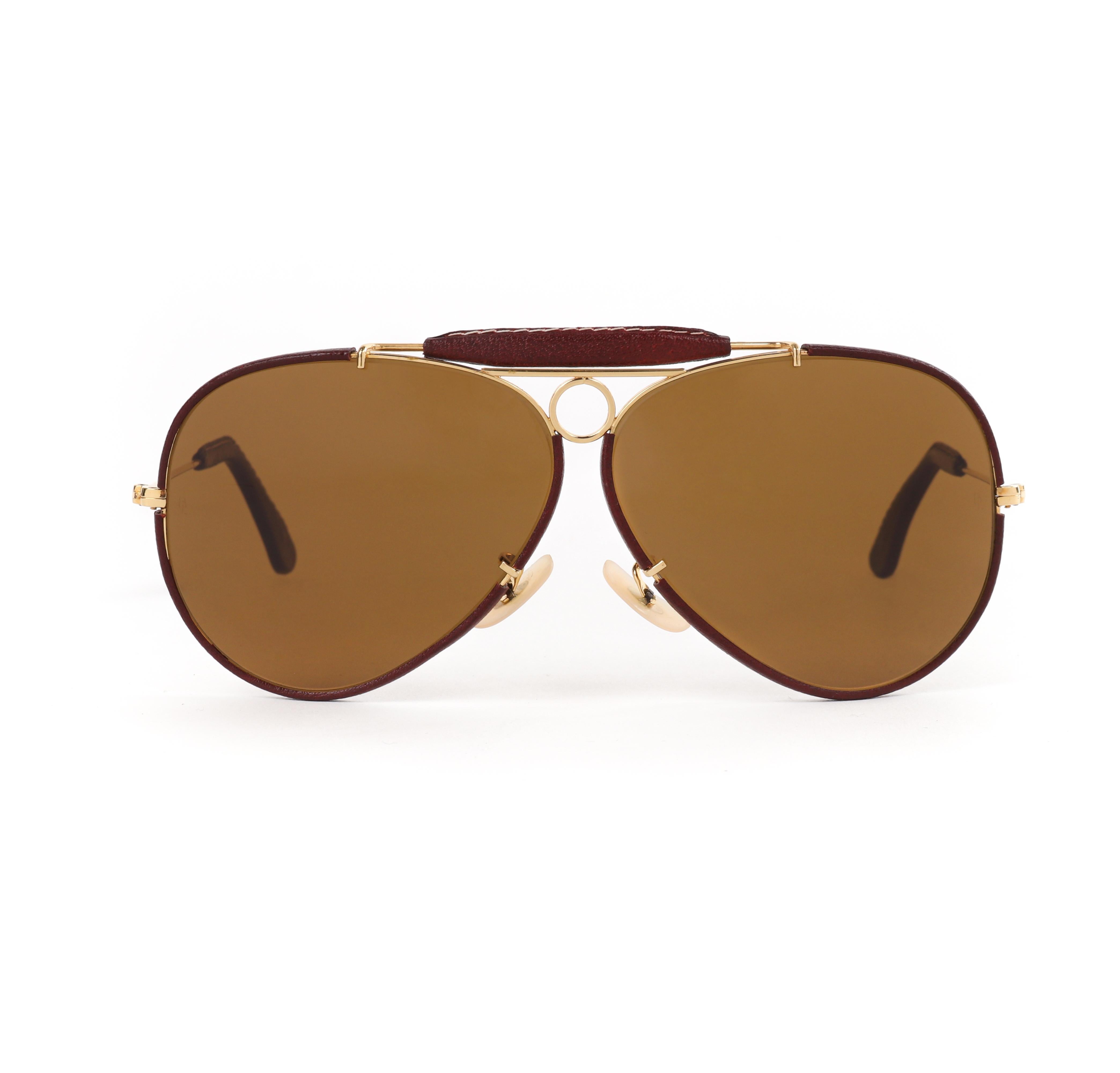 RAY BAN Bausch & Lomb c.1970's Gold Burgundy Leather Aviator Shooter Sunglasses
 
Brand / Manufacturer: Ray Ban (Bausch & Lomb era)
Circa: 1970's
Style: Aviator 