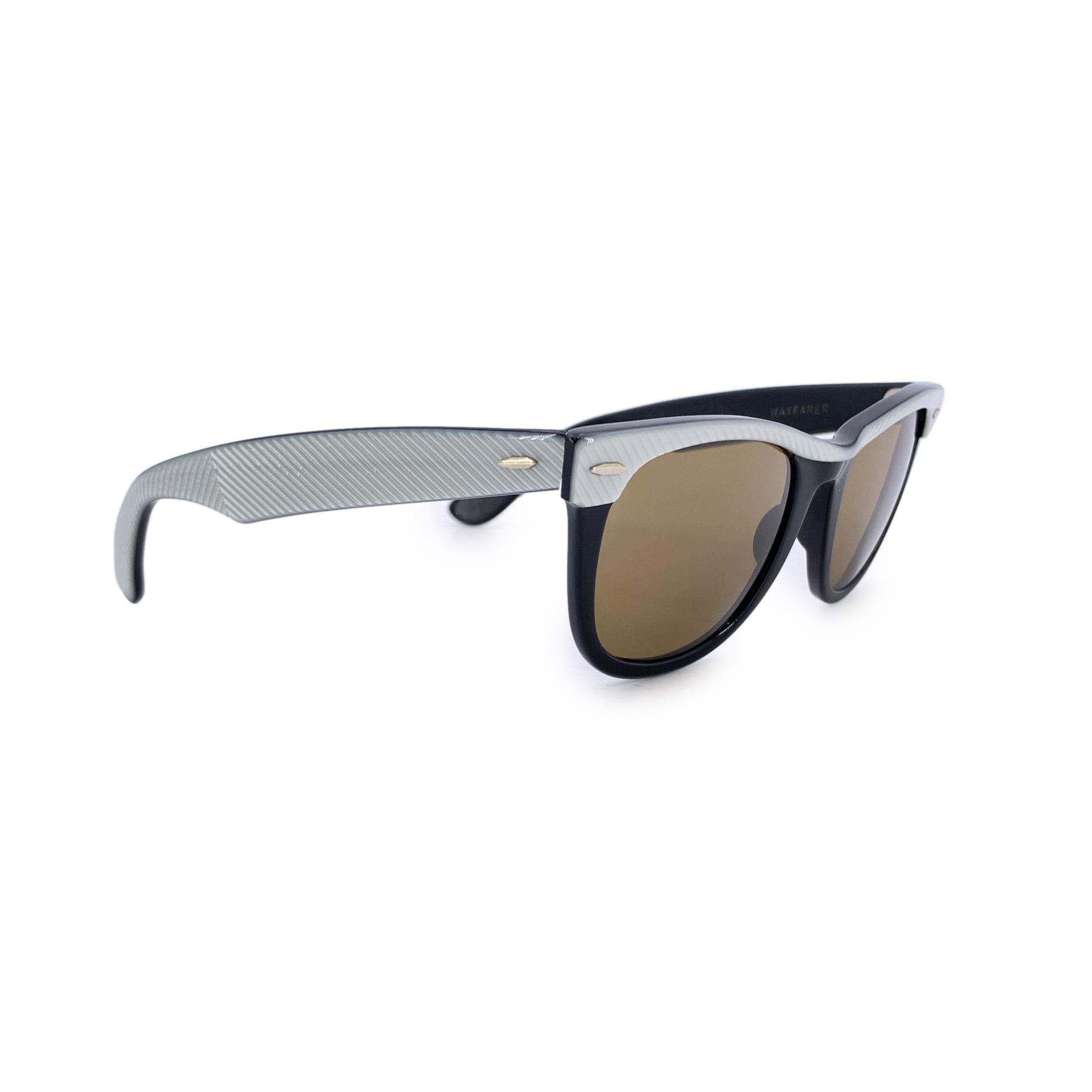Vera reliquia di uno stile intramontabile, questi occhiali da sole Ray-Ban B&L Vintage Black Acetate Wayfarer RB 5022 incarnano lo spirito audace dei decenni passati. Il modello RB 5022 si distingue per la sua sicura montatura nera e un sottile ma
