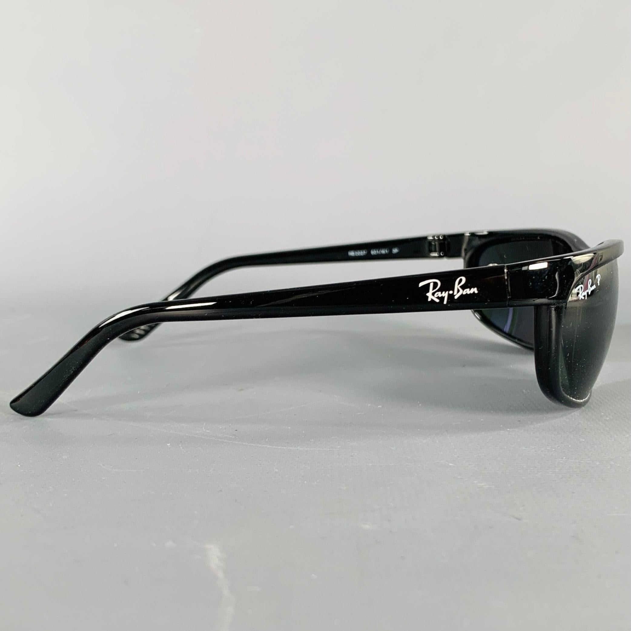 RAY-BAN sunglasses
in a black acetate featuring a wrap around style and polarized lenses. Comes with case. Made in Italy.Very Good Pre-Owned Condition. 

Marked:   RB2027 601/W1 3P 

Measurements: 
  Frame Width: 14 cm.Frame Height: 3.5 cm. 
  
  
