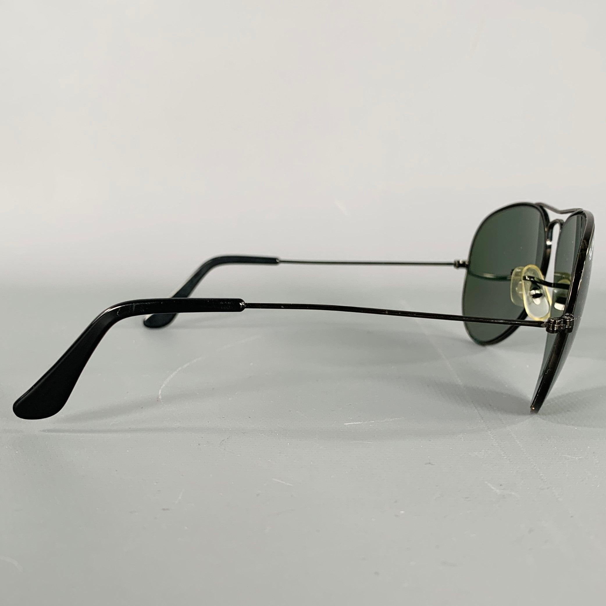 RAY-BAN sunglasses
in a black metal featuring an aviator style with tinted lenses. Comes with case.Very Good Pre-Owned Condition. 

Measurements: 
  Frame Width: 13.5 cm.Frame Height: 5 cm. 
  
  
 
Sui Generis Reference: 134107
Category: Sunglasses