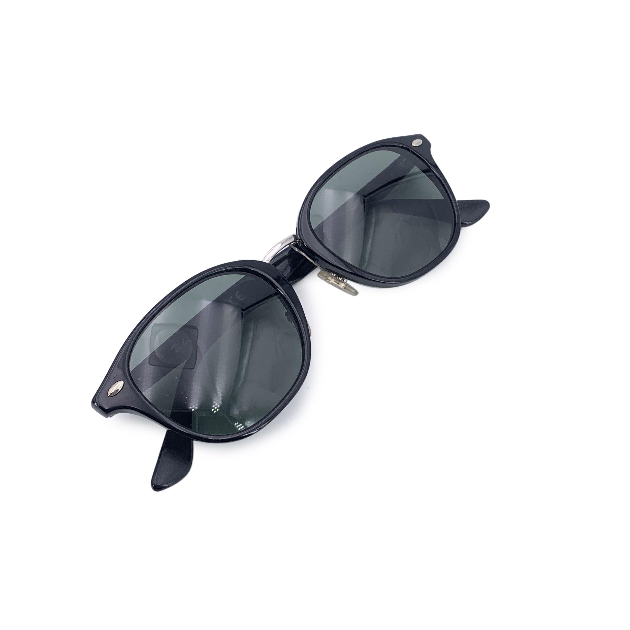 Con un taglio audace e un look inconfondibile, questi occhiali da sole vintage neri Ray-Ban, modello RB 5355, sono un'impressionante reliquia della fine degli anni '80, quando le forme geometriche e la moda senza paura dominavano la scena. La loro