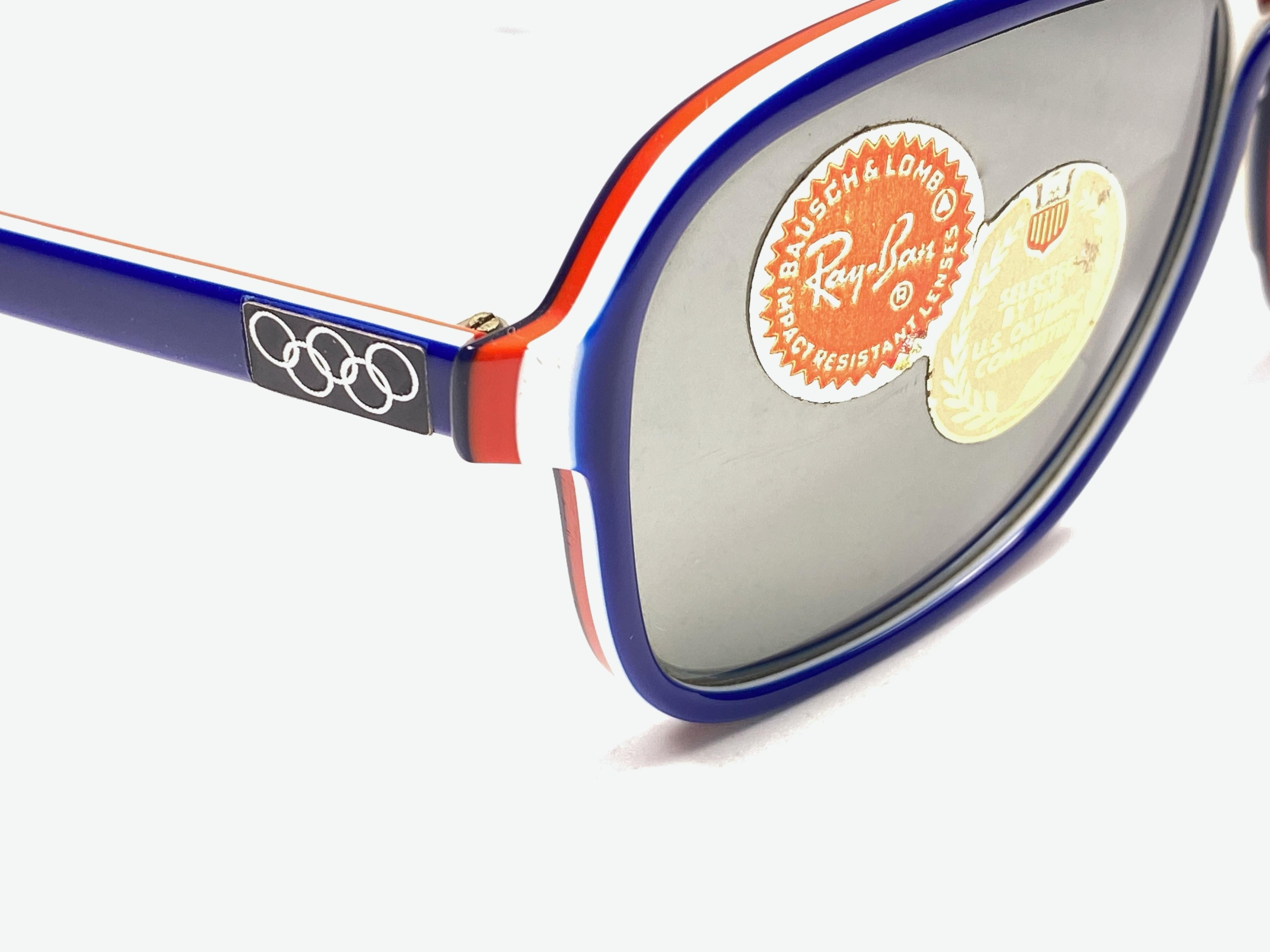 Neuwertige Ray Ban Stateside in blauer:: roter und weißer Kombination mit vollverspiegelten Gläsern. 

Dieses Paar weist aufgrund der fast 40-jährigen Lagerung leichte Gebrauchsspuren auf. 

Entworfen und hergestellt in den USA. 

FRONT : 14.5 CM 